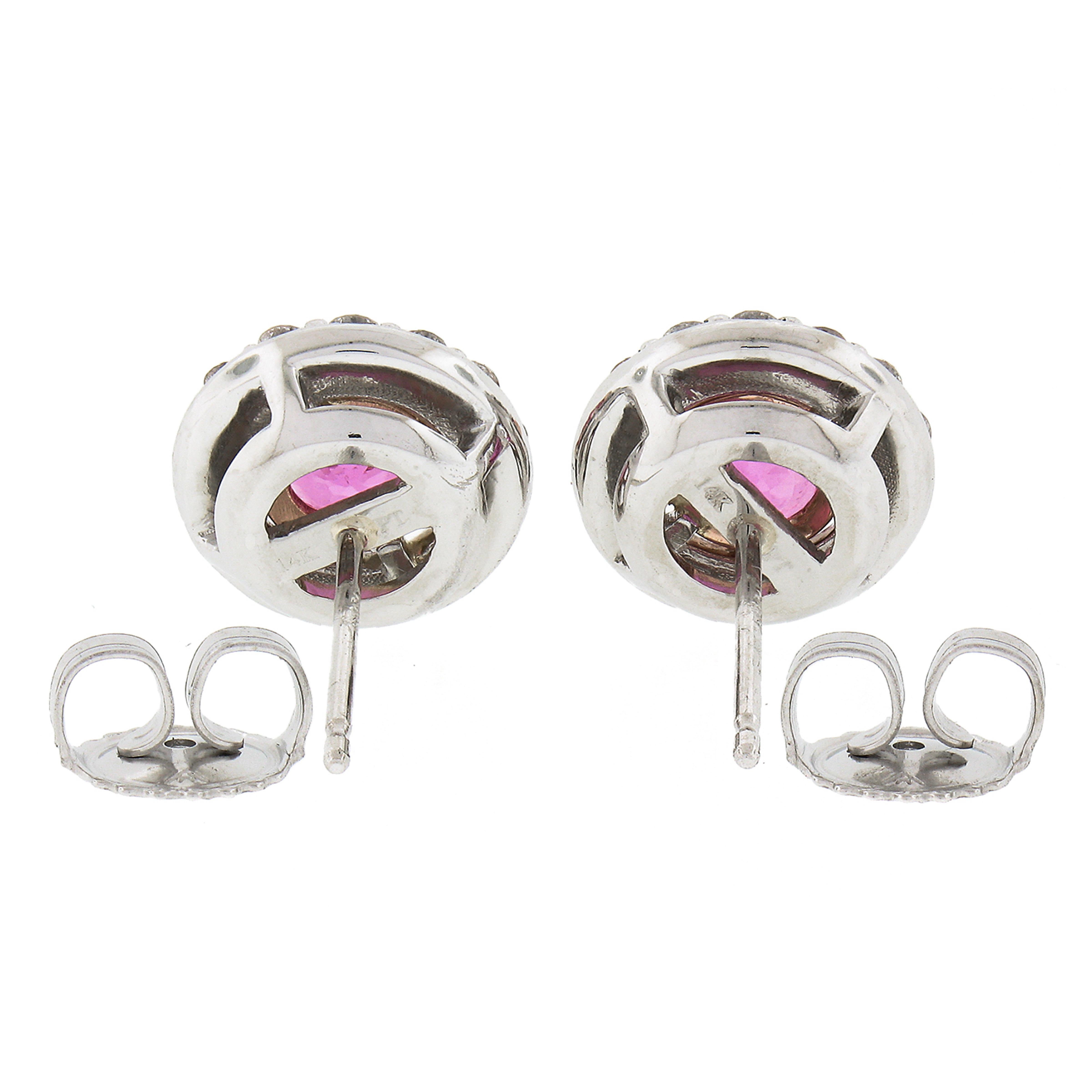 Si tratta di uno splendido paio di orecchini a grappolo con zaffiri e diamanti, realizzati in platino massiccio e oro rosa 14k. Ogni orecchino è incastonato al centro con uno zaffiro rosa taglio brillante rotondo di ottima qualità. Gli zaffiri