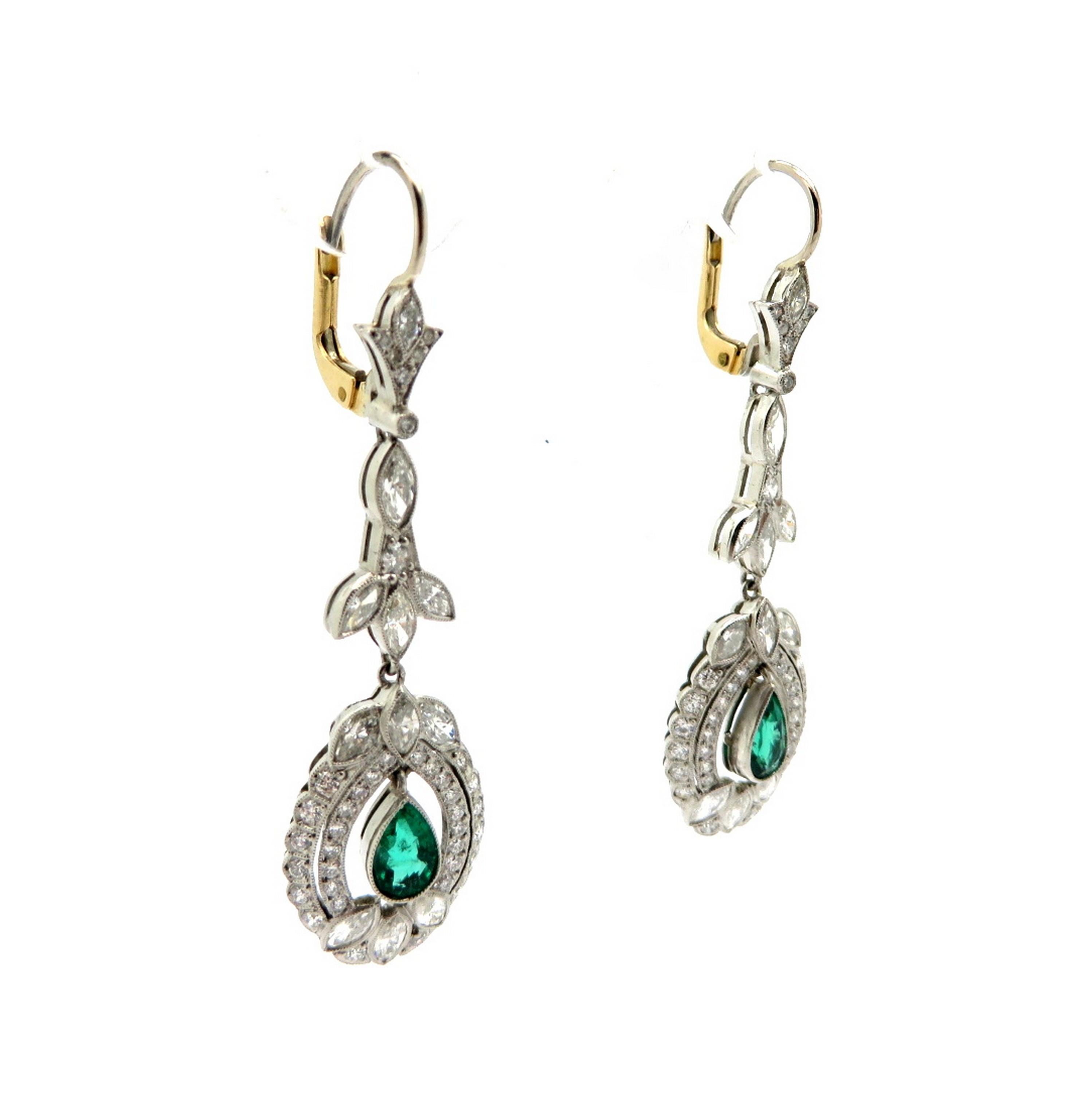 Estate platinum and 14K yellow gold antique Old European cut emerald and diamond dangle earrings. Showcasing two pear shaped fine quality natural emeralds, milgrain bezel set, weighing a total of approximately 1.15 carats. Accented with numerous Old