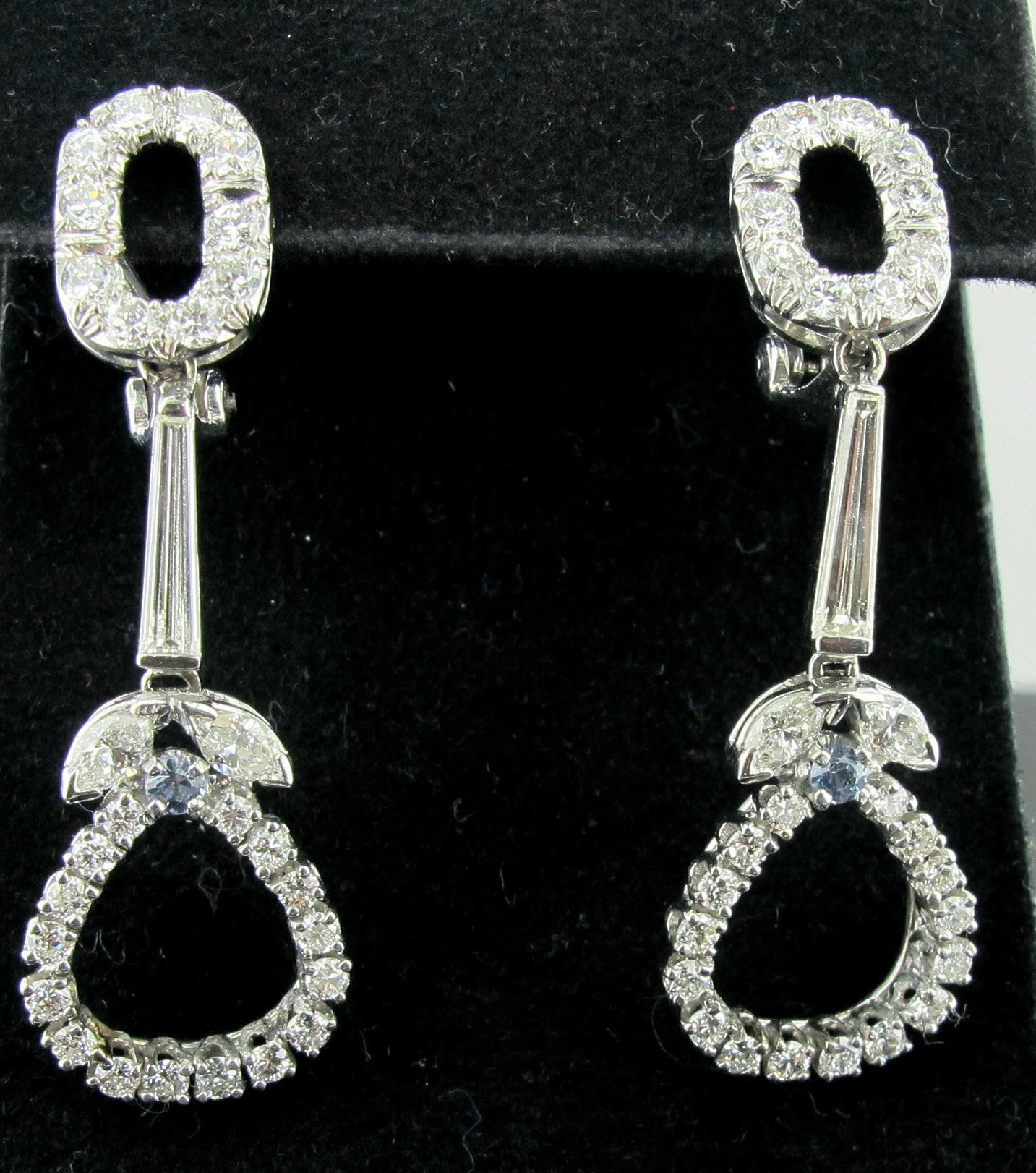Set in 14 karat white gold tops with Platinum bottoms, are 58 diamonds with a total weight of 2.36 carats, G color, VS Clarity. Diamonds consist of 4 Marquise, 2 Baguettes, and 52 round brilliant cuts.  Also included are two round aquamarines