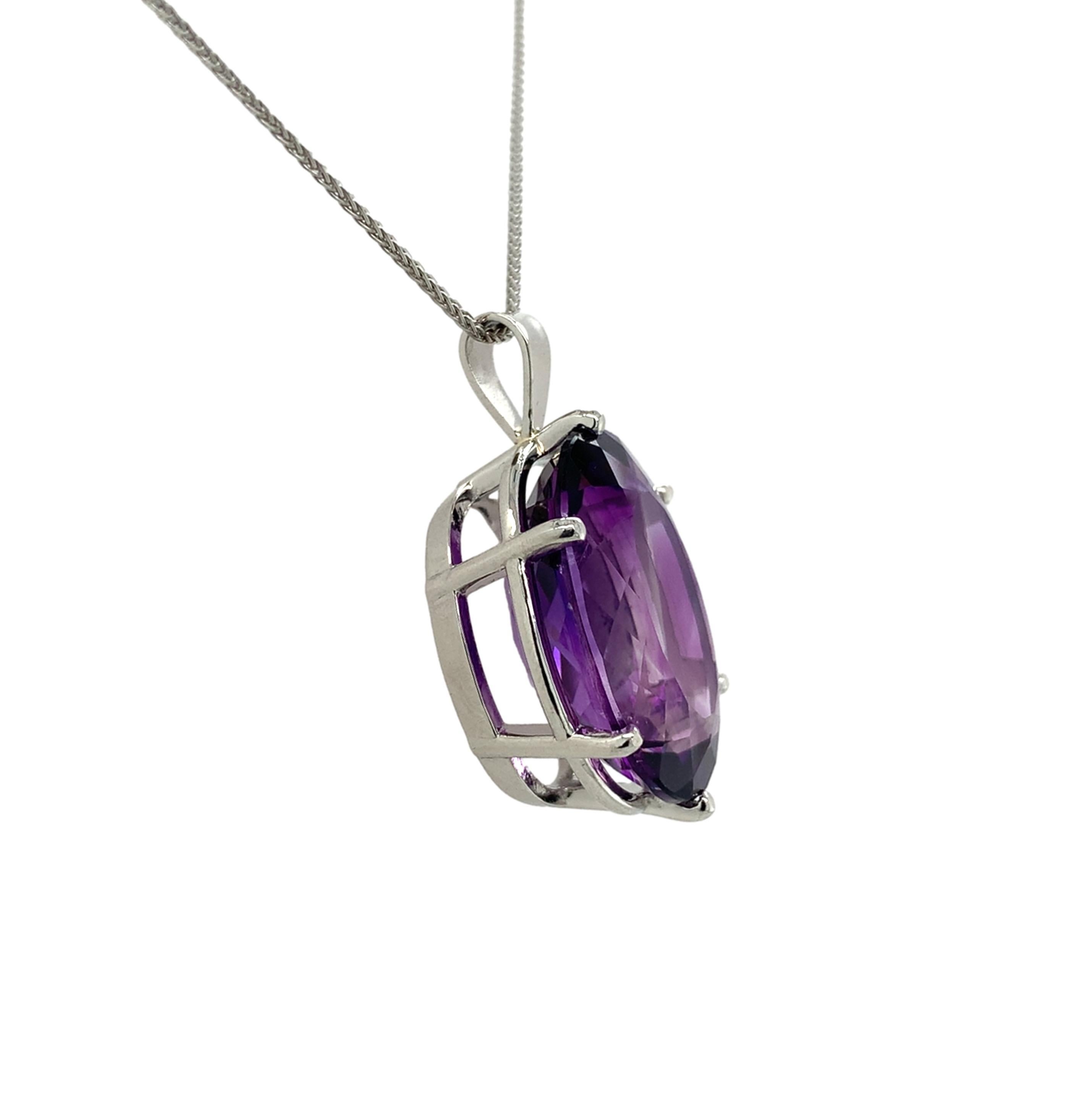 Pendentif en platine orné d'une améthyste de taille ovale. L'améthyste a une belle couleur pourpre royal avec des éclats fuchsia. L'améthyste pèse 16,33 carats et mesure environ 20 mm x 15 mm. Le pendentif mesure un peu plus d'un pouce de long avec