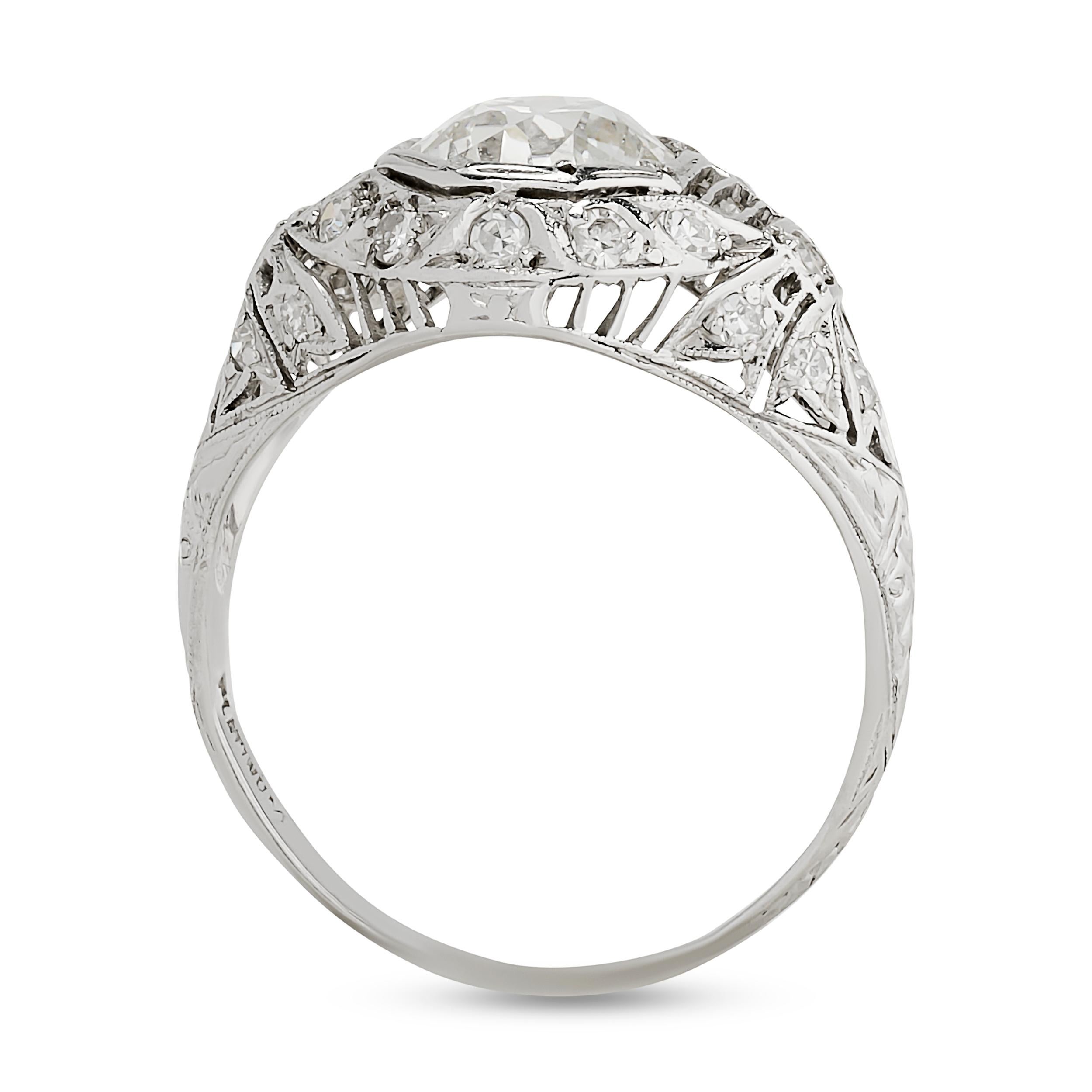 Cette bague en platine est ornée d'un diamant taille coussin de vieille mine niché dans une monture octogonale, rehaussée de filigrane, de milgrain et d'accents diamantaires complexes, reflétant une élégance romantique.

Diamant central taille