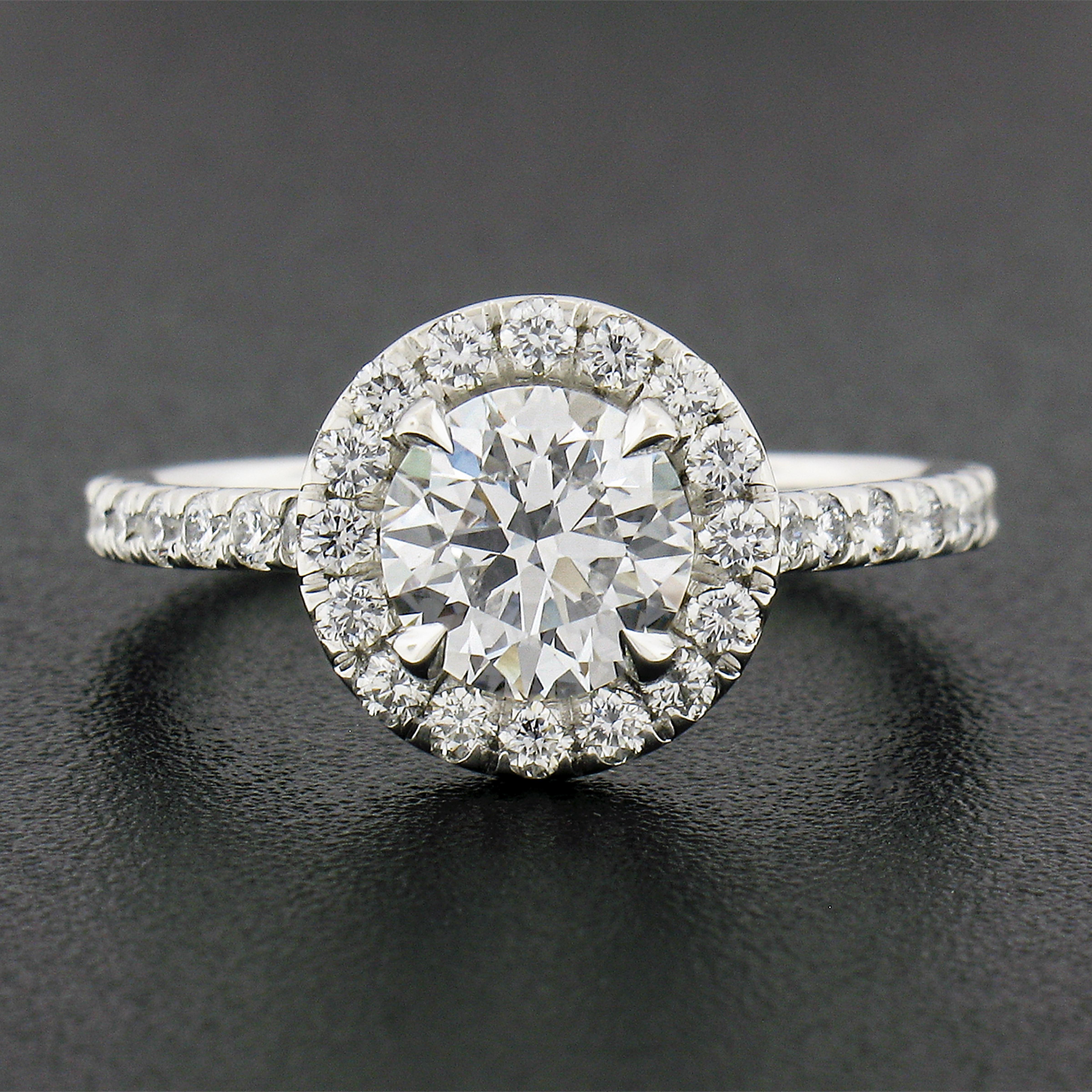 Here we have a gorgeous diamond engagement ring that is newly crafted from solid platinum. The ring features a stunning super high quality GIA certified, round brilliant cut diamond claw prong set at the center.The halo and both shoulders are neatly