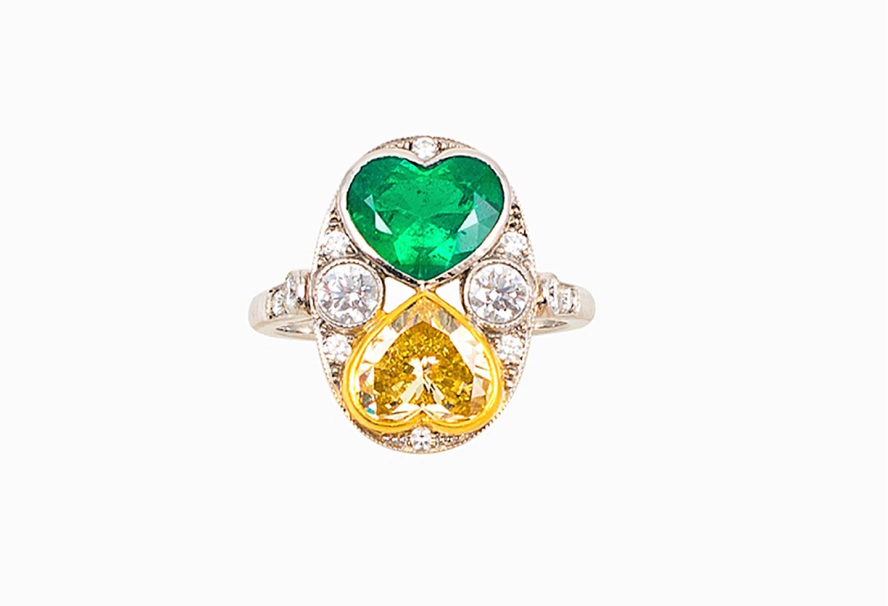 This one-of -a-kind ring is so special. The oval-shaped head of this platinum ring centers one bezel-set 1.75 carat, VIVID Green, mixed-cut heart-shaped emerald, and one 1.75 carat Fancy Yellow, brilliant-cut heart-shaped diamond in an 18 karat gold