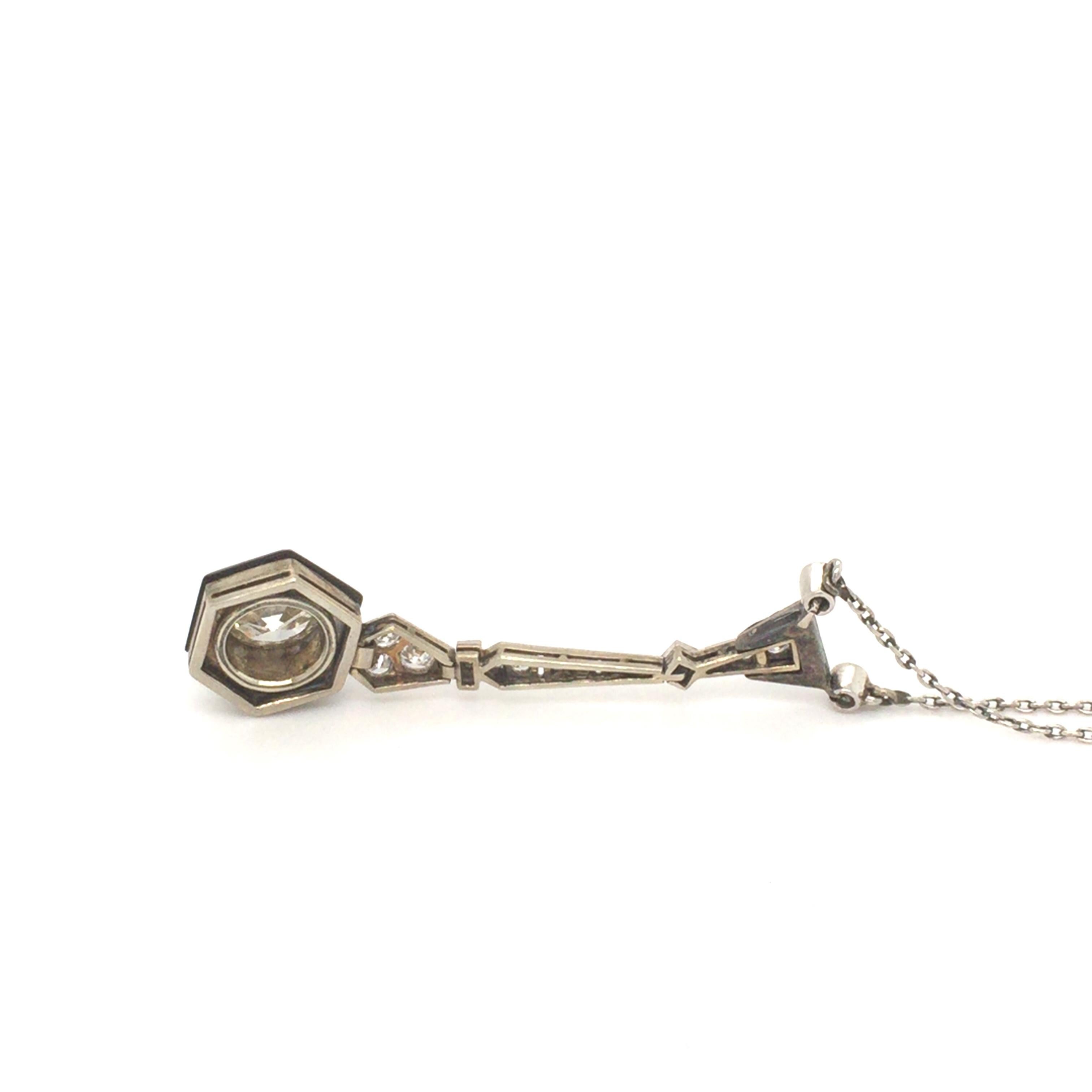 Llamativo collar colgante Art Déco histórico con diamantes, ónice y esmalte negro. Delicadamente elaborada a mano en oro blanco y platino con motivos geométricos engastados con diamantes talla antigua en un engaste millegrain típico de la época Art