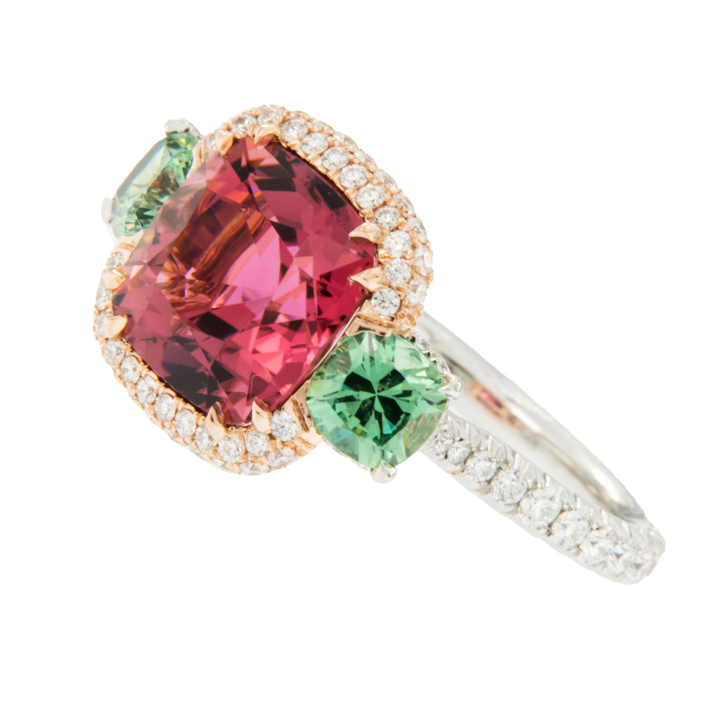 Made in New York & known for his superb, finest quality gems & craftsmanship, this exceptional ring showcases a lovely hued Rubelite set in 18 karat rose gold diamond halo, flanked by 2 natural, unenhanced Demantoid Garnets = 1.28 Cttw. Demantoid's