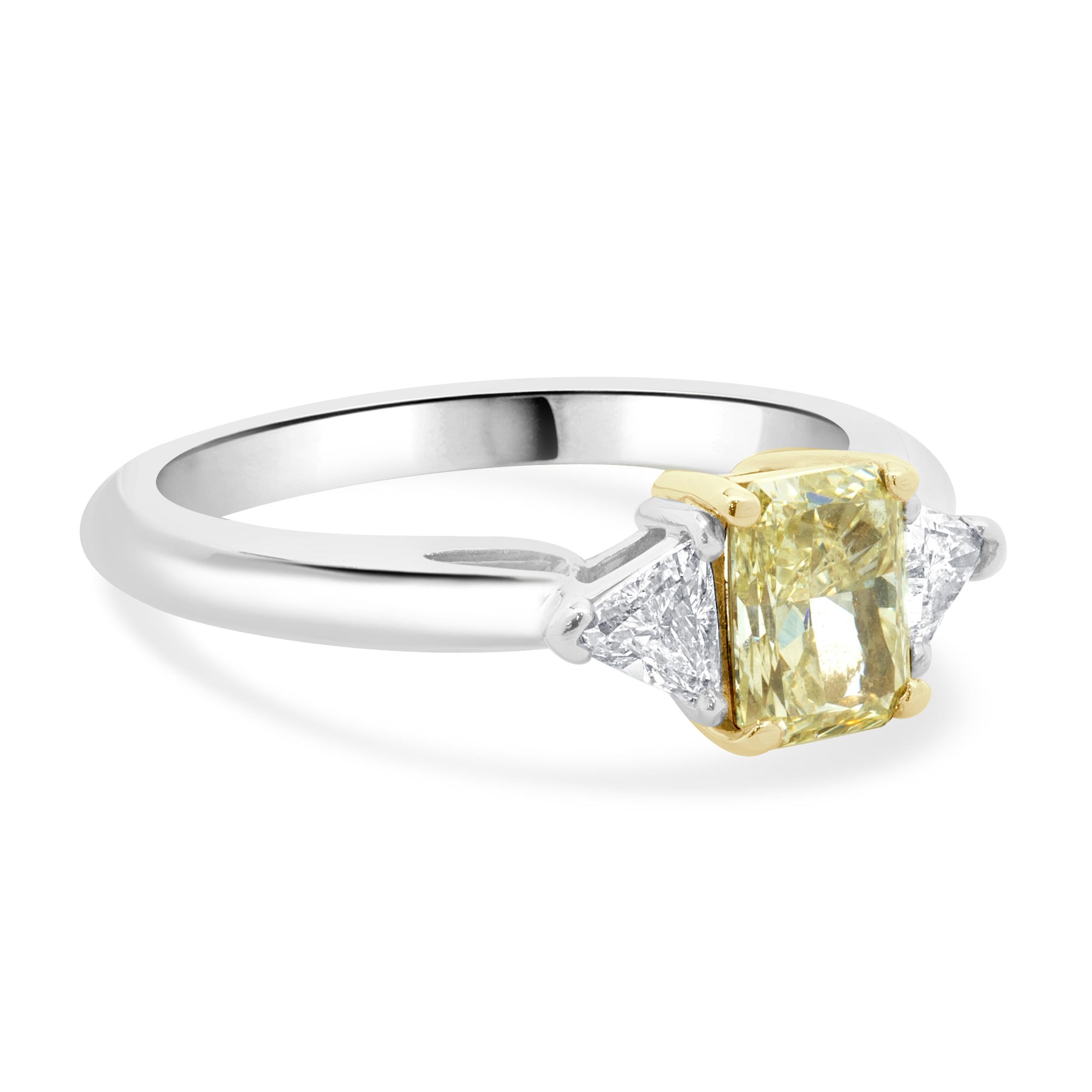 Designer: custom
Material: platinum & 18K yellow gold
Diamond: 1 radiant cut = 1.00ct
Color: Fancy Light Yellow
Clarity: VS2
Diamond: 2 trillion cut = 0.25cttw
Color: H
Clarity: SI2
Dimensions: ring top measures 7mm wide
Ring Size: 6.5
