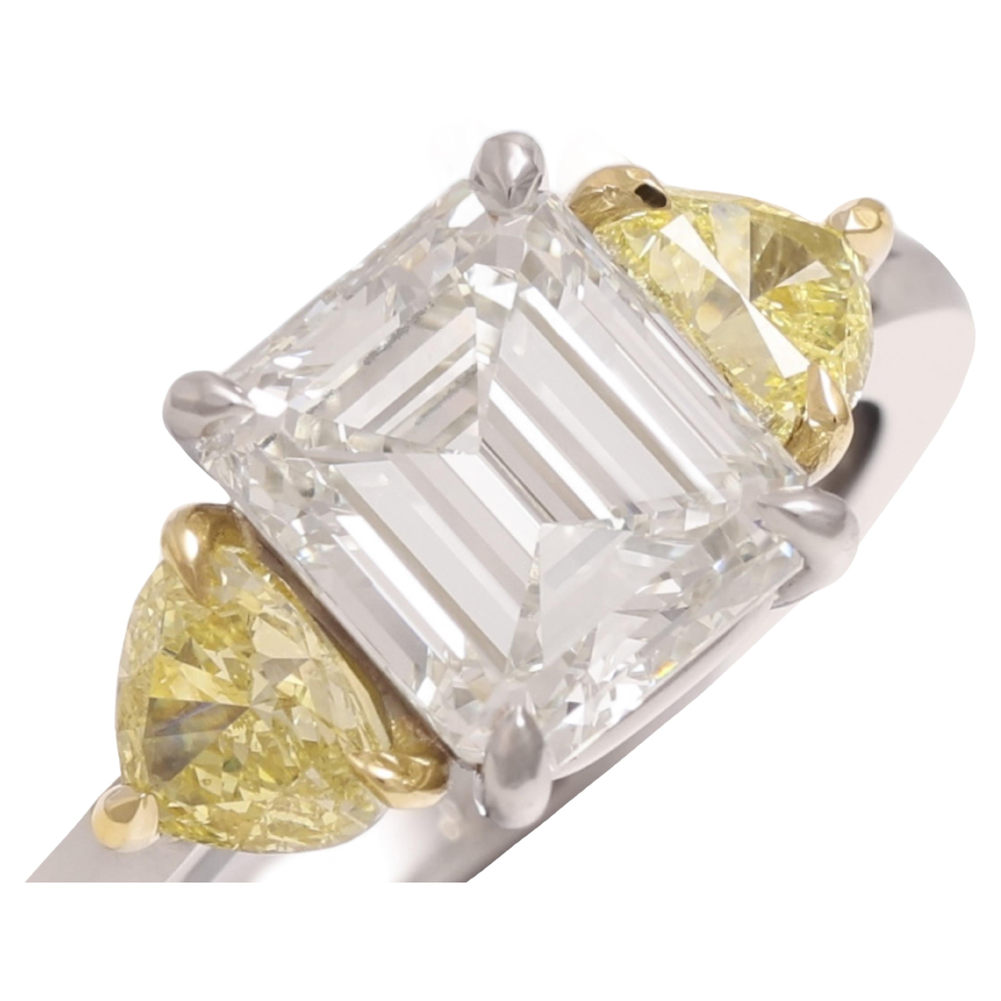 Magnificant Platinum & 18 kt. Ring With 2.88 ct. Emerald Cut, 2 Triangle Cut Diamonds

Diamond:  
Emerald cut, white diamond of 2.88 ct. J VVS1
2 Intense fancy yellow triangle cut diamonds 1.17 Ct

Material: Platinum with 18 kt. yellow gold

Ring