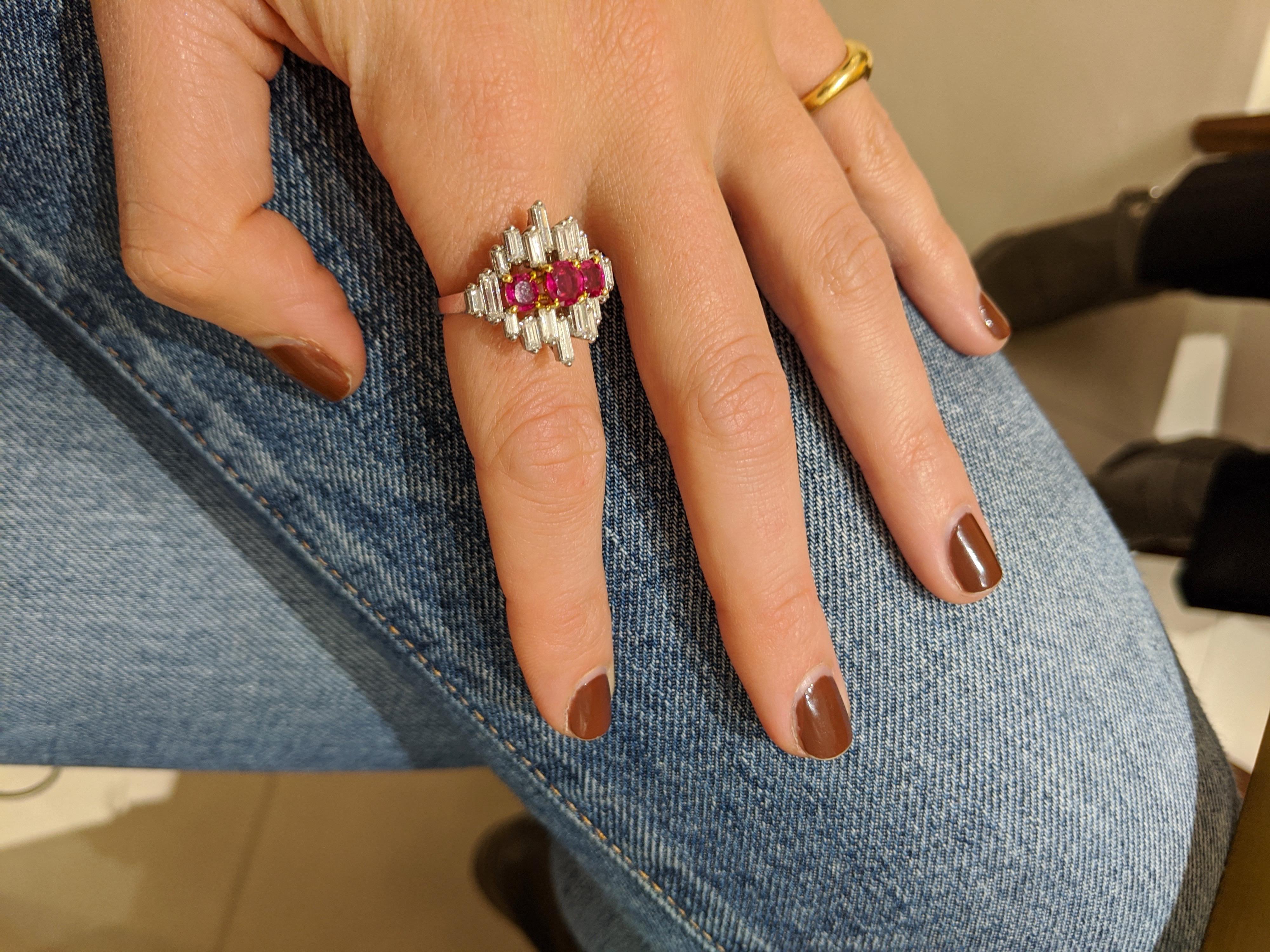 This is a very elegant cocktail ring. Designed in platinum with diamond baguettes set vertically,  the ring has a very Art Deco feeling. Three oval cut rubies highlight the center.
Total diamond weight 1.80 carats
Total ruby weight 1.26 carats
Ring