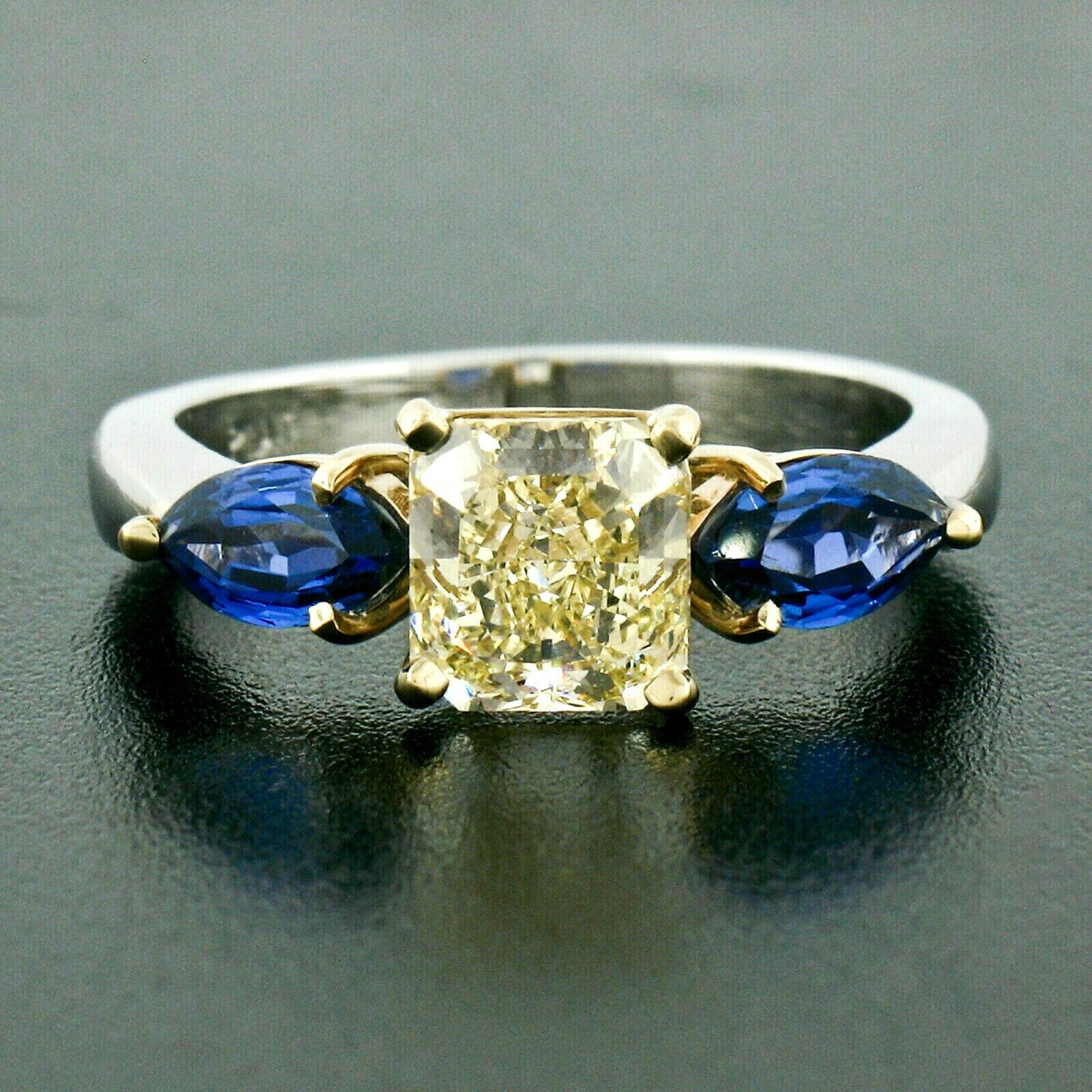Sie sehen hier einen wirklich atemberaubenden Verlobungsring mit drei Diamanten und Saphiren, handgefertigt aus massivem Platin und 18 Karat Gelbgold. Der Ring verfügt über eine wirklich atemberaubende GIA-zertifiziert, strahlenden Schliff, fancy