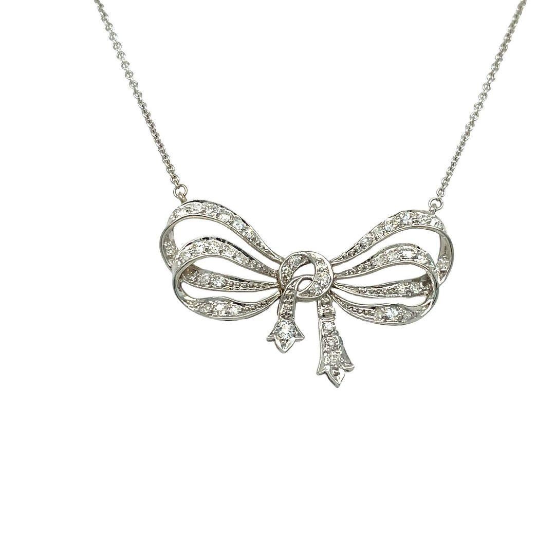 This adorable necklace features an exquisite bow-shaped platinum mounting. The graceful bow motif represents femininity and sophistication. It showcases old mine diamonds, approximately 1.80 carats in total weight, with F-G color and VS clarity. The