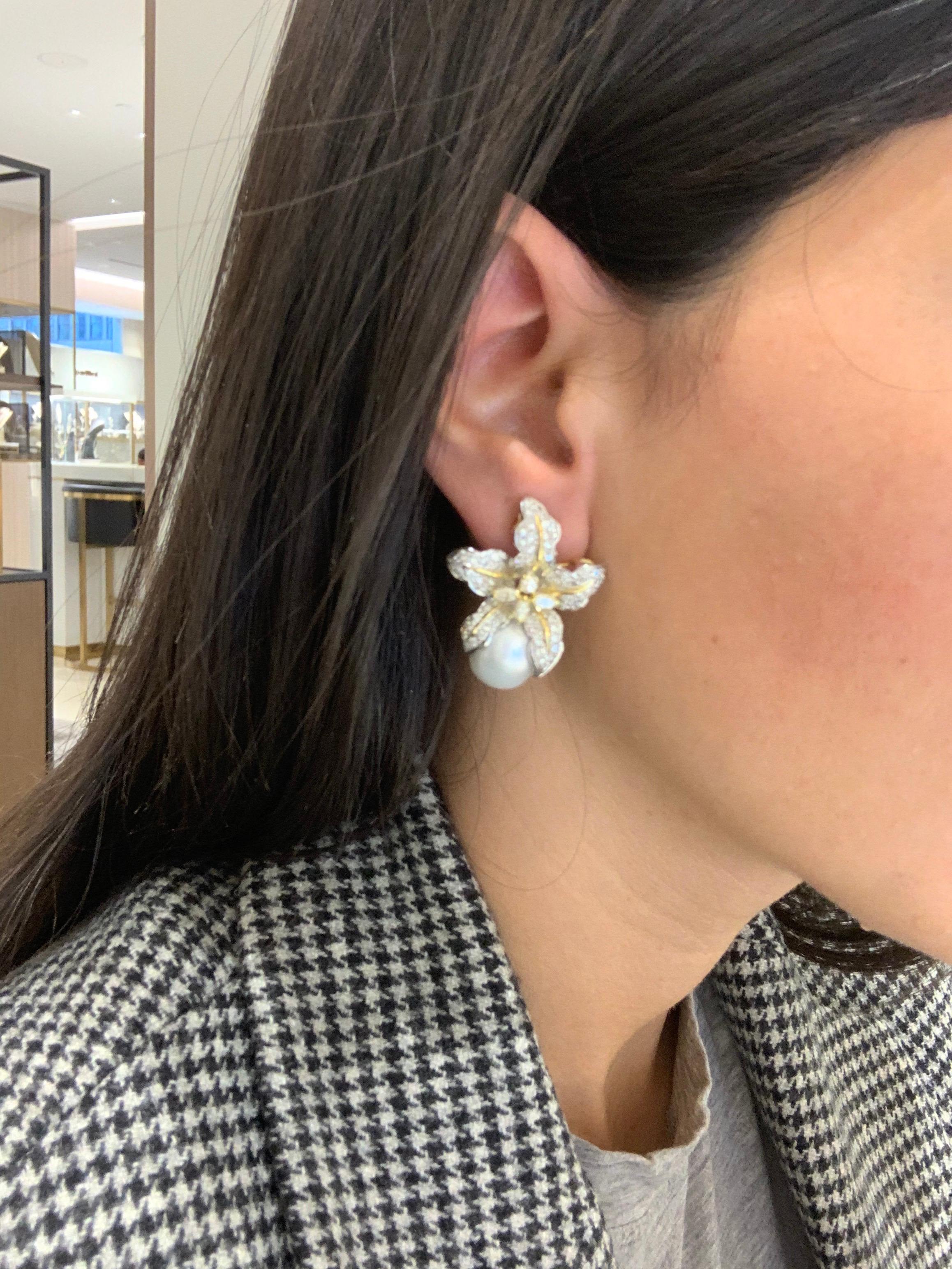 These lovely earrings are designed with a beautifully detailed orchid that has been set with round brilliant pave diamonds. The center area of the flower is prong set with 3 marquise cut and 1 round brilliant cut diamond. The setting is a