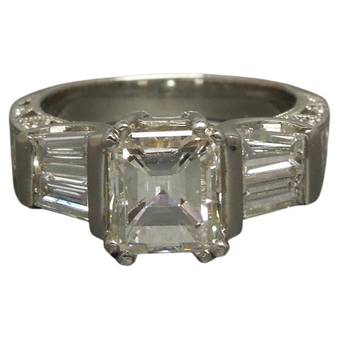 Constructed completely of Platinum, with 1 Central 1.92 carat Asscher cut Diamond ranking a J Color & Nearly Flawless VVS1 Clarity at 7mm x 6.2mm securely set in a 4-Prong Setting.  With a total of 4 Immediately Side set Colorless Nearly Flawless