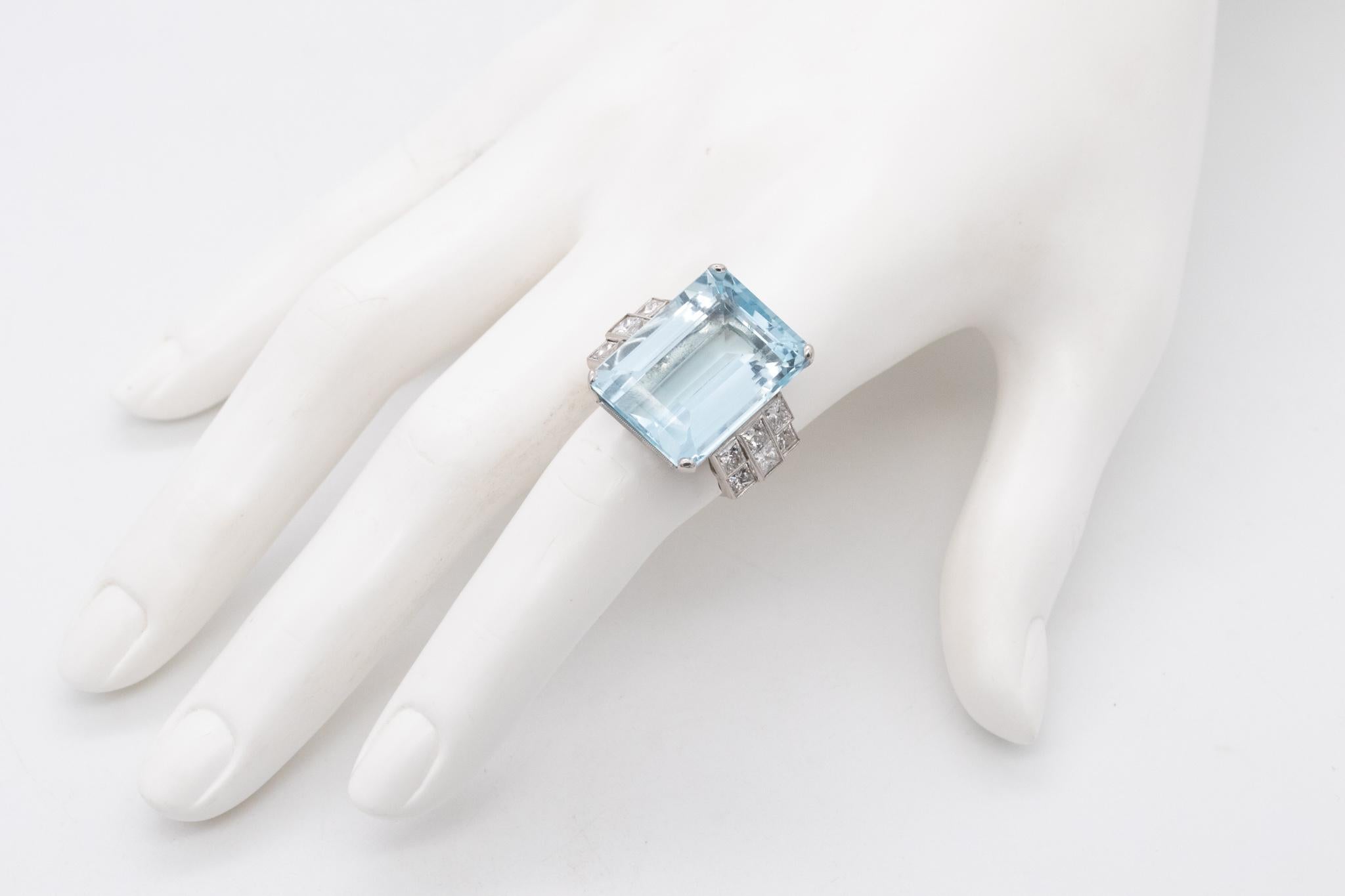Statement cocktail ring with a large Aquamarine.

An impeccable piece from the American art deco period, circa 1940. Is was crafted in solid .900/.999 platinum and mounted in the center with an emerald step cut (22 x 16 x 10 mm) of a natural blue