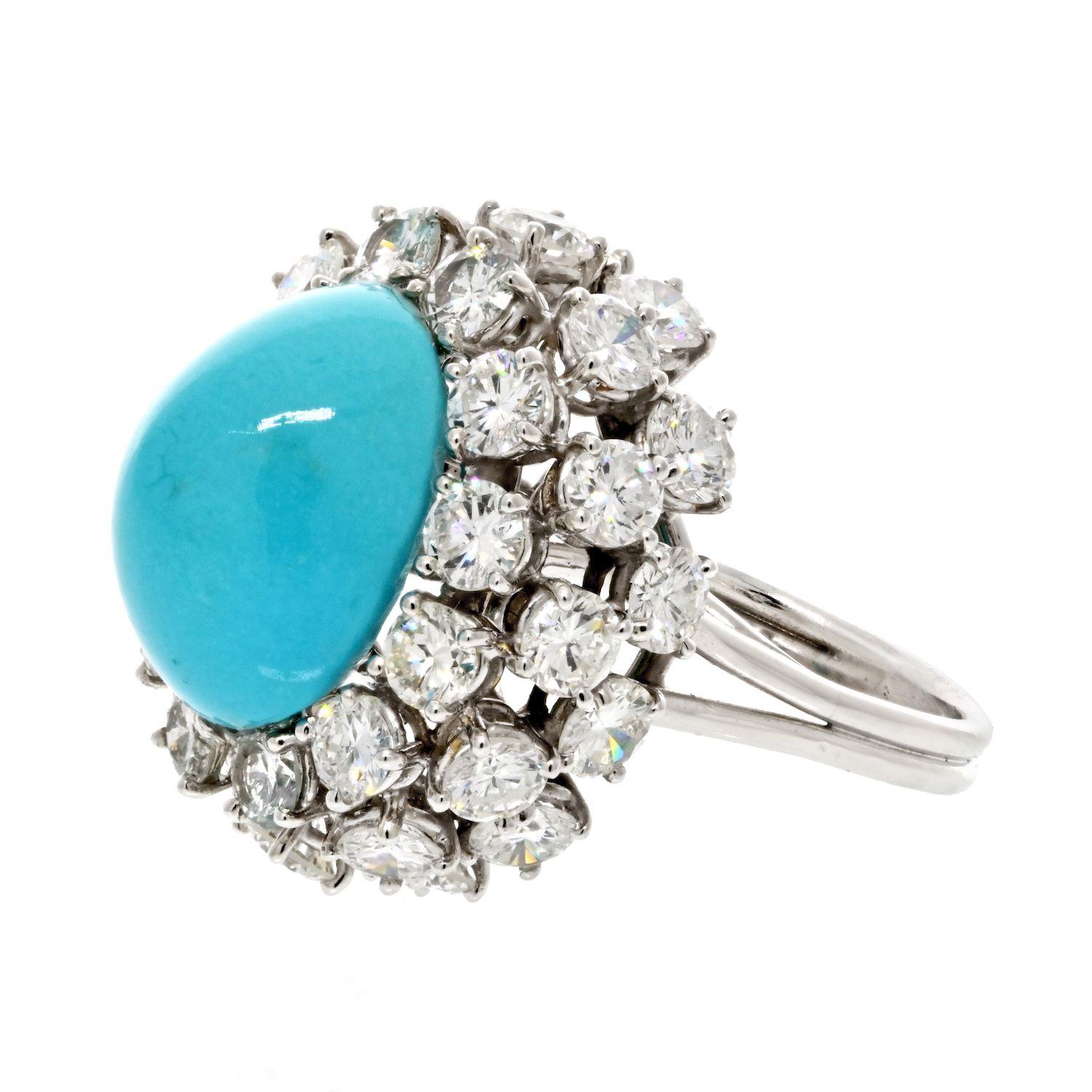 The Platinum 1960's Diamond and Cabochon Cut Turquoise Cocktail Ring is a captivating vintage piece that combines the allure of diamonds with the vibrant beauty of turquoise. Crafted in platinum, this ring showcases a remarkable cabochon cut