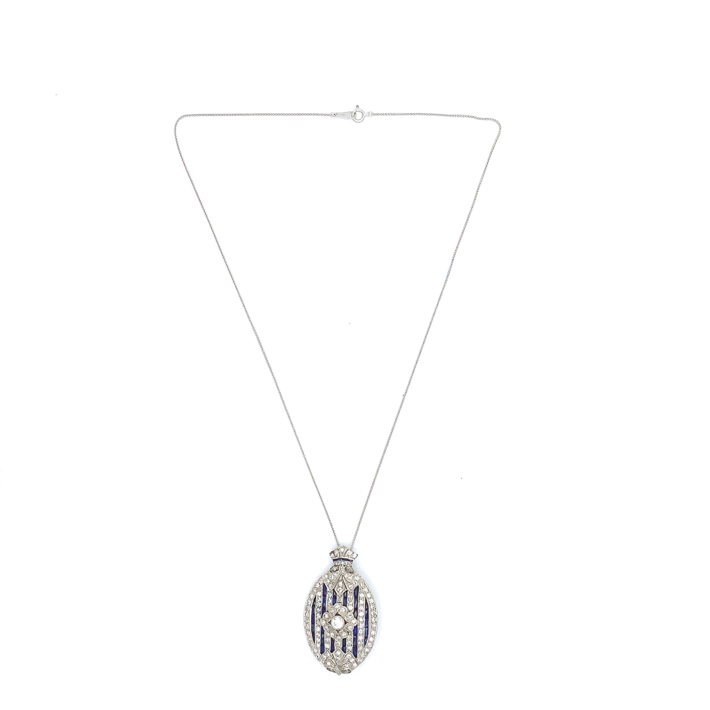 Platinum Art Deco pendant with 2 carats of diamonds accented by specialty French calibre cut synthetic sapphires. Beautiful design with bows and a central rosette. There are about 117 round transitional and single cut diamonds weighing a total of 2
