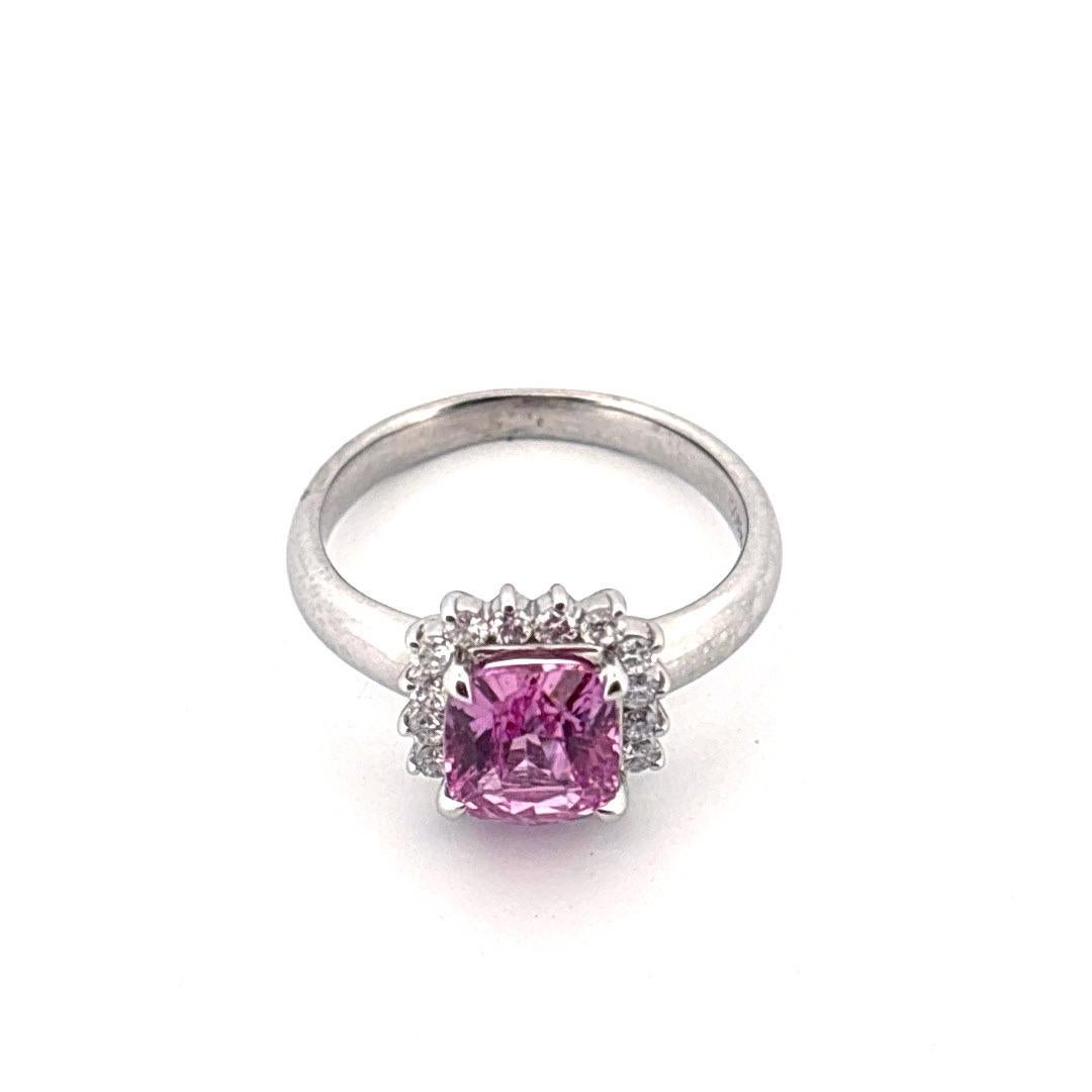 Questo anello in platino, che emana un'eleganza femminile e un fascino senza tempo, è caratterizzato da uno zaffiro rosa taglio cuscino da 2,01 carati. La gemma rosa vivida vanta una brillantezza e una limpidezza eccezionali, splendidamente