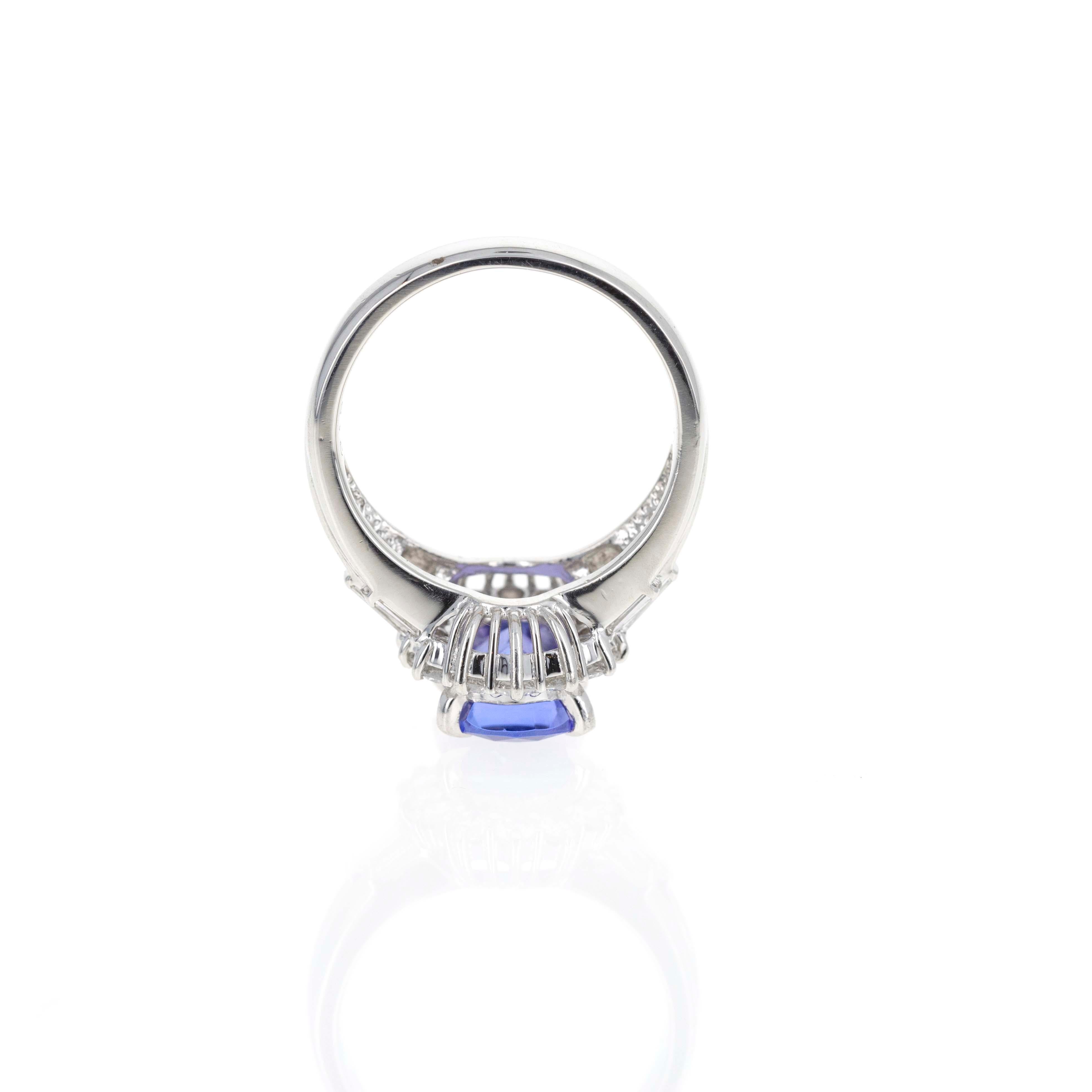 Era: New
Composition: Platinum
Primary Stone: Cushion Cut Natural Tanzanite
Carat Weight: 2.18 Carats
Accent Stone: Fourteen Round Brilliant & Six Baguette Diamonds
Carat Weight: 0.94 Carats in Total
Color/Clarity: F-G / SI1-VS2
Ring Size: 6
Ring