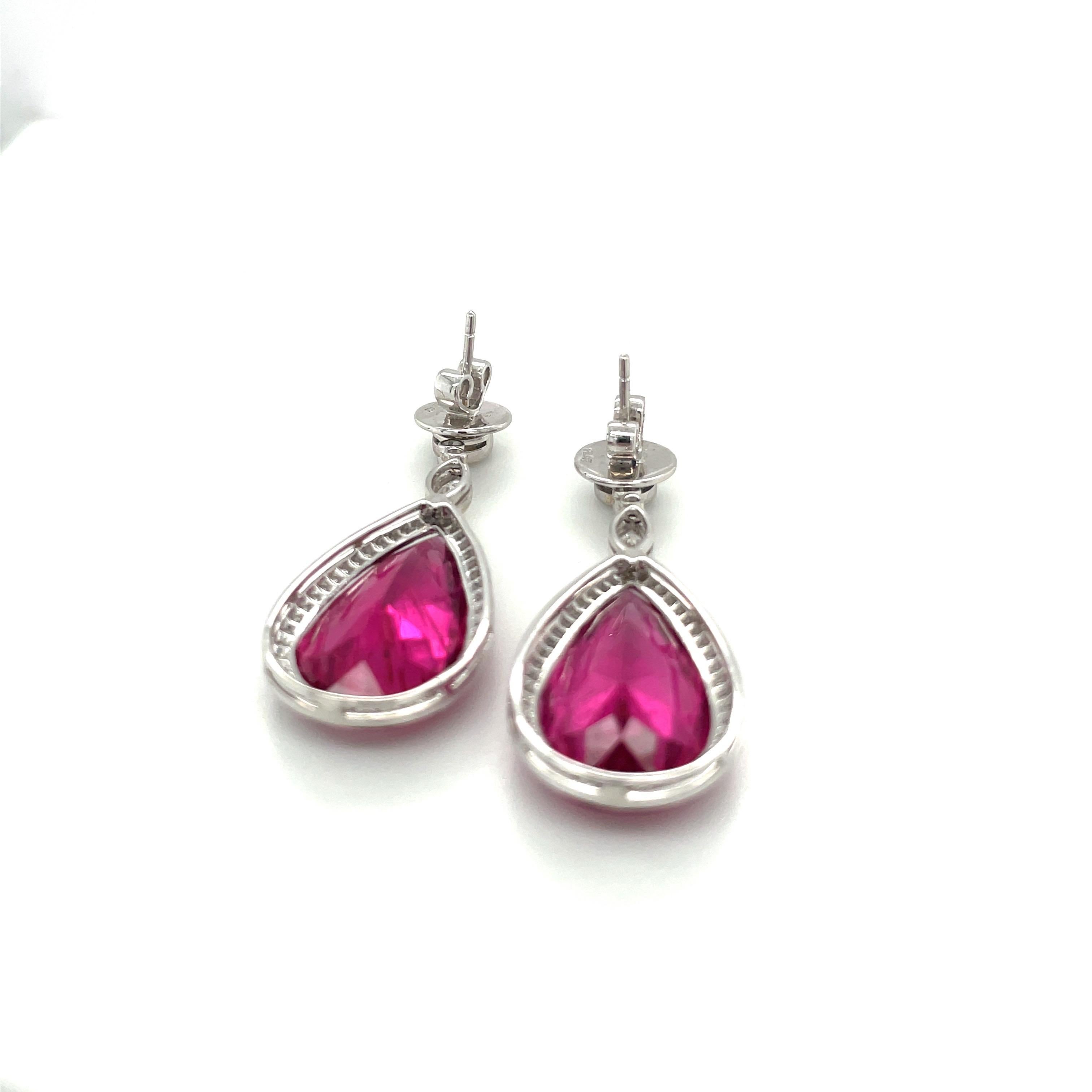 These stunning pear shaped rubelite earrings are beautifully set in a flat wire micro-pavé diamond  setting.Round brilliant and marquis diamonds accent the top of these platinum post earrings. The earrings measure 1-7/8
