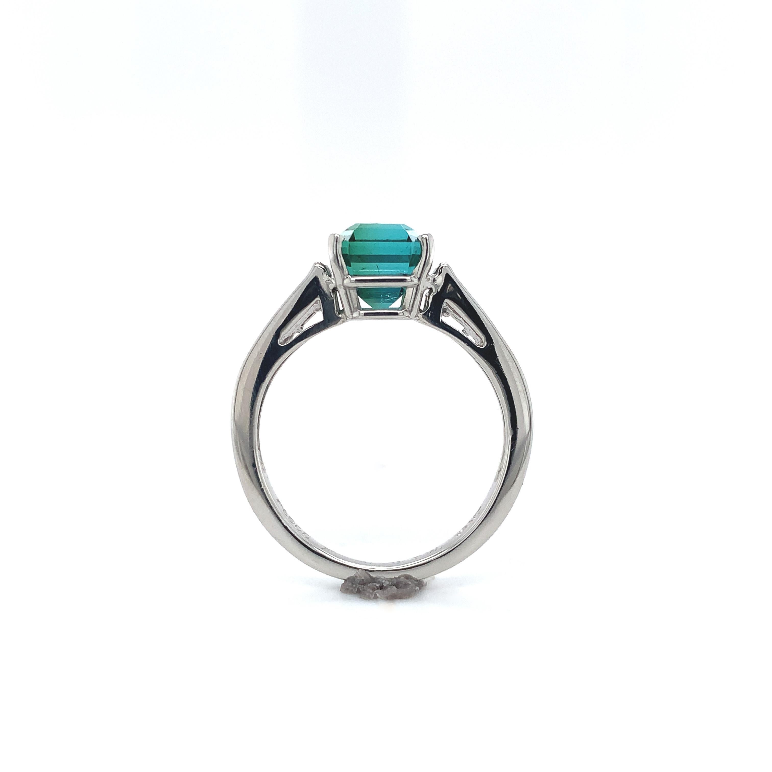 Platinum 2.30 carat green tourmaline ring. The intense chrome green color with slight blue undertones is a fine quality. The tourmaline has an asscher or square step cut measuring about 7mm x 6.7mm. There are 16 diamond baguette accents graduating
