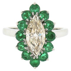 Anello in platino con diamante giallo chiaro marquise da 2,30 carati e smeraldo rotondo a raggiera