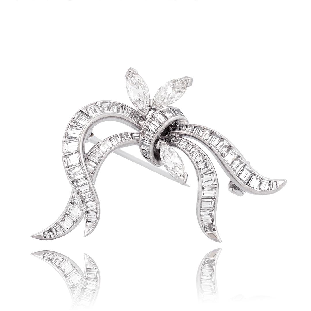 This platinum diamond set brooch features three marquise diamonds sprouting from the top weighing approximately 0.65 carats combined. The other 56 baguette diamonds weighing approximately 1.68 total carats cascade down in four ribbon-like streamers.