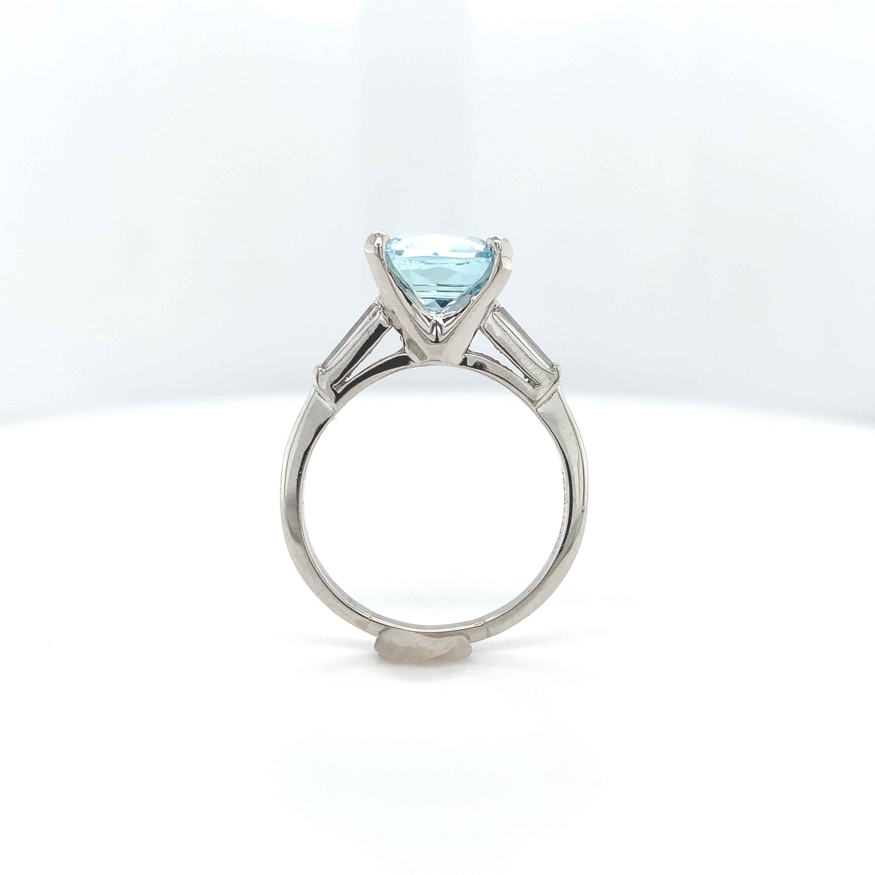 Platinum 2.51 carat aquamarine and diamond ring. The light blue aquamarine is a beautiful specialty antique cushion cut measuring about 9mm. There are 2 long diamond baguette accents measuring about 5mm x 1.5mm. The ring fits a size 7.25 finger and
