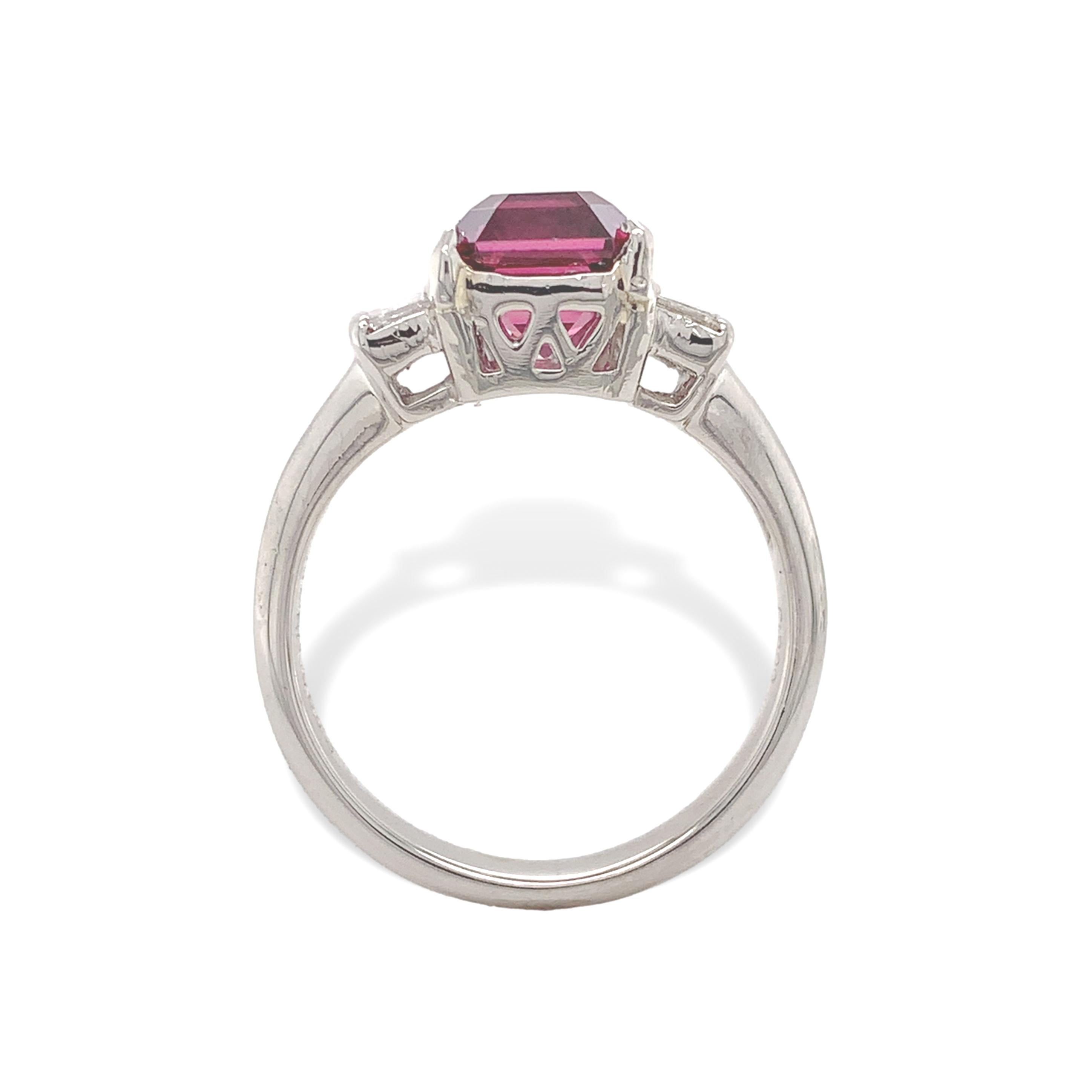Platinum garnet and diamond ring featuring a very pretty raspberry colored umbalite garnet weighing 2.55 carats. The garnet measures about 7.5mm x 6.8mm. The garnet has a step cut top, similar to an emerald cut but with a faceted pavilion similar to