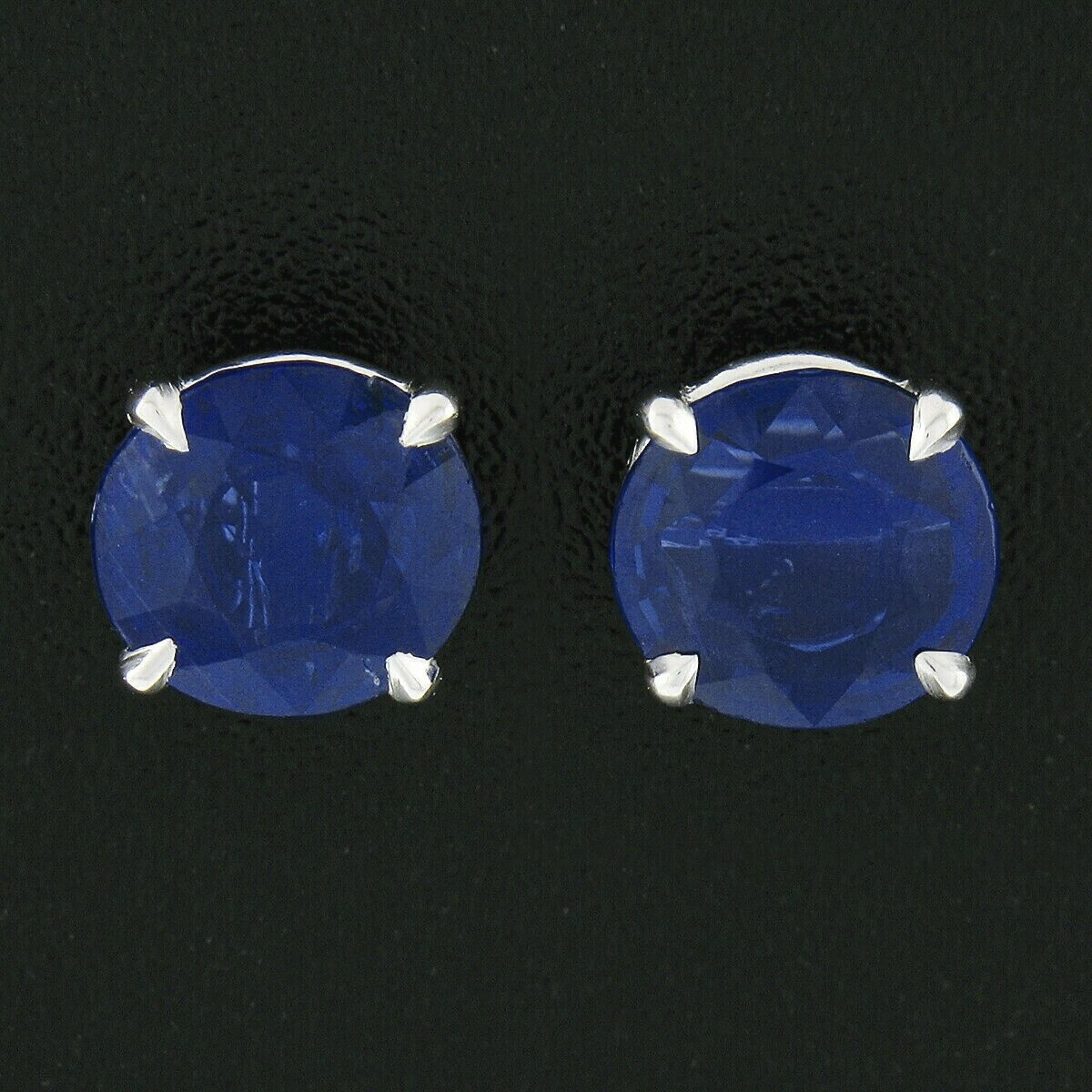 This classically styled pair of sapphire stud earrings is newly crafted in solid platinum and feature a pair of stunning, vintage, oval brilliant cut sapphires neatly claw-prong set into well made open baskets. These fat oval stones are GIA