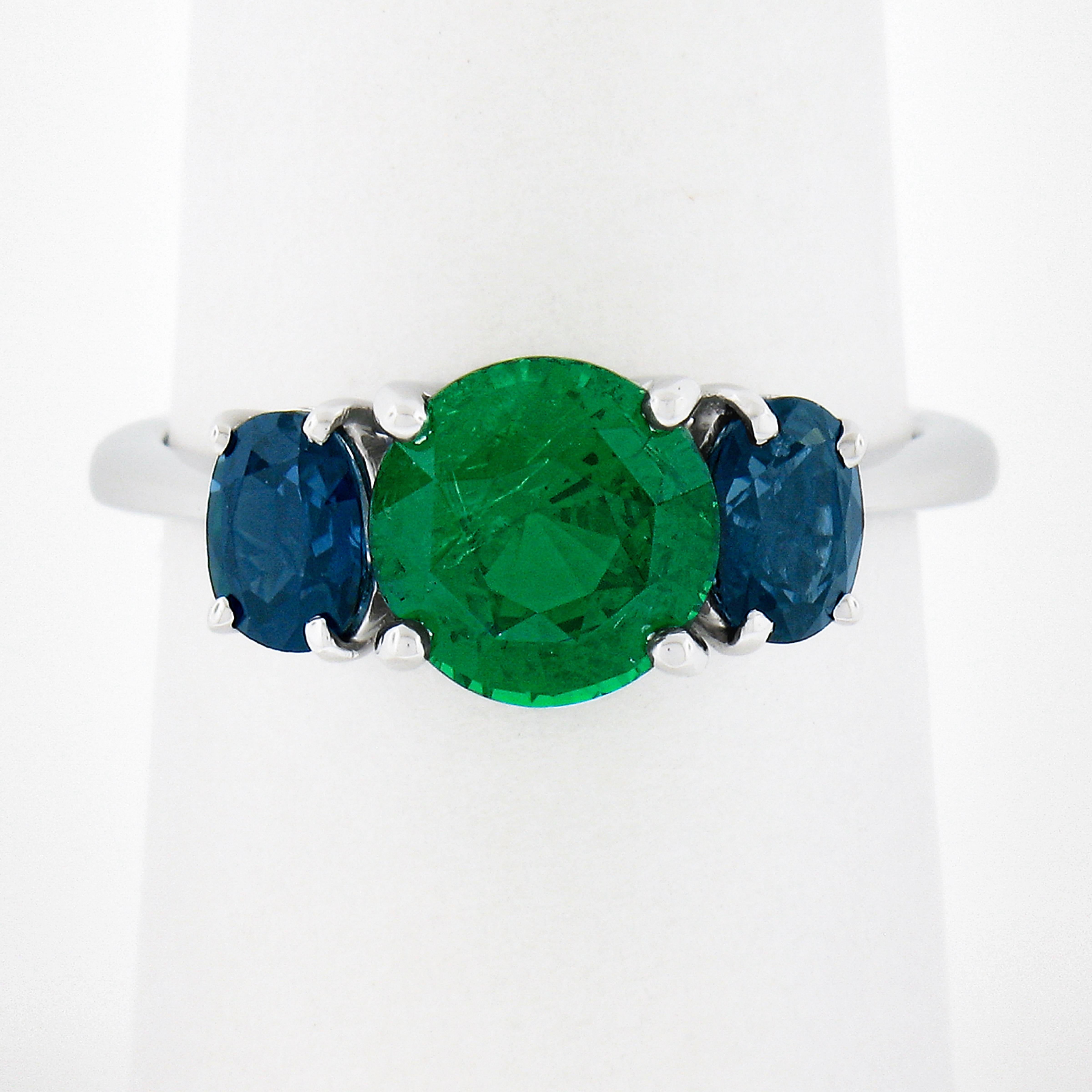 Here we have an absolutely beautiful ring that is crafted in solid platinum. The ring features a, GIA certified, natural tsavorite stone that weighs exactly 2.09 carats and is neatly prong set at the center of the three stone setting design. This