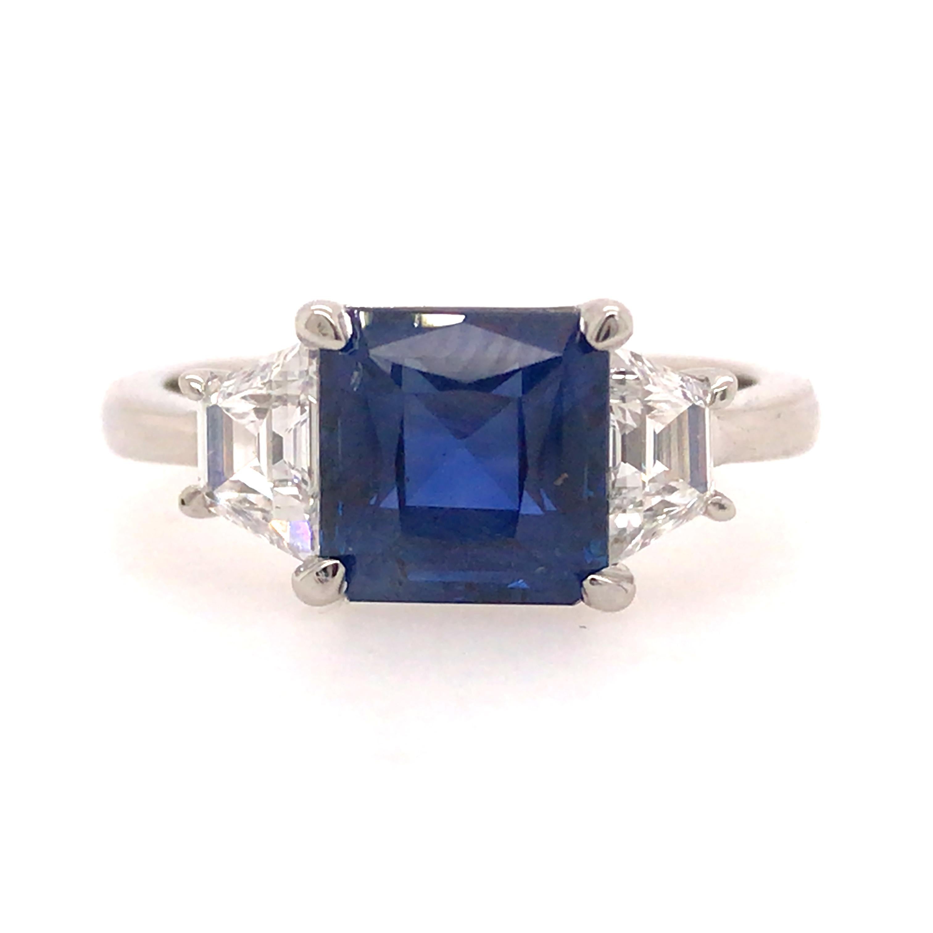 Sapphire and Diamond Three Stone Ring in Platinum.  2.92 Carat GIA Burma No Heat Octagonal Sapphire is flanked with (2) Trapezoid Cut Diamonds weighing 0.66 carat total weight, E-F in color and VS in clarity.  Ring size 6 1/2. 6.06 grams.  GIA