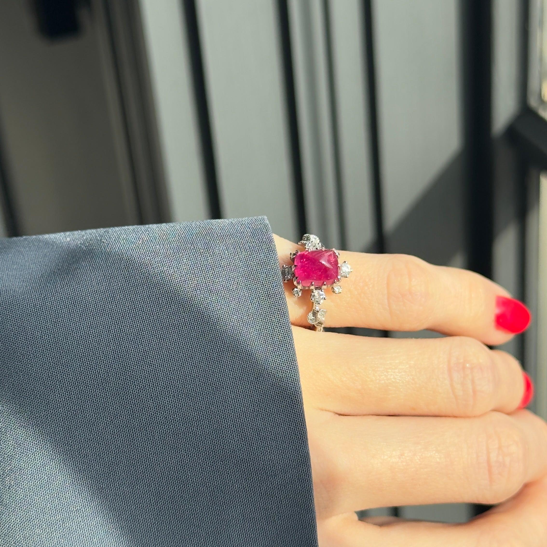 Era: Retro Estate
Composition: Platinum 
Primary Stone: One Natural Sugar Loaf Ruby
Carat Weight: Approximately 2.95 Carats
Accent Stone: Twenty-Six Round Brilliant Diamonds
Carat Weight: 0.33 Carats In Total
Color/Clarity: SI1-2 / F-G
Ring Size: