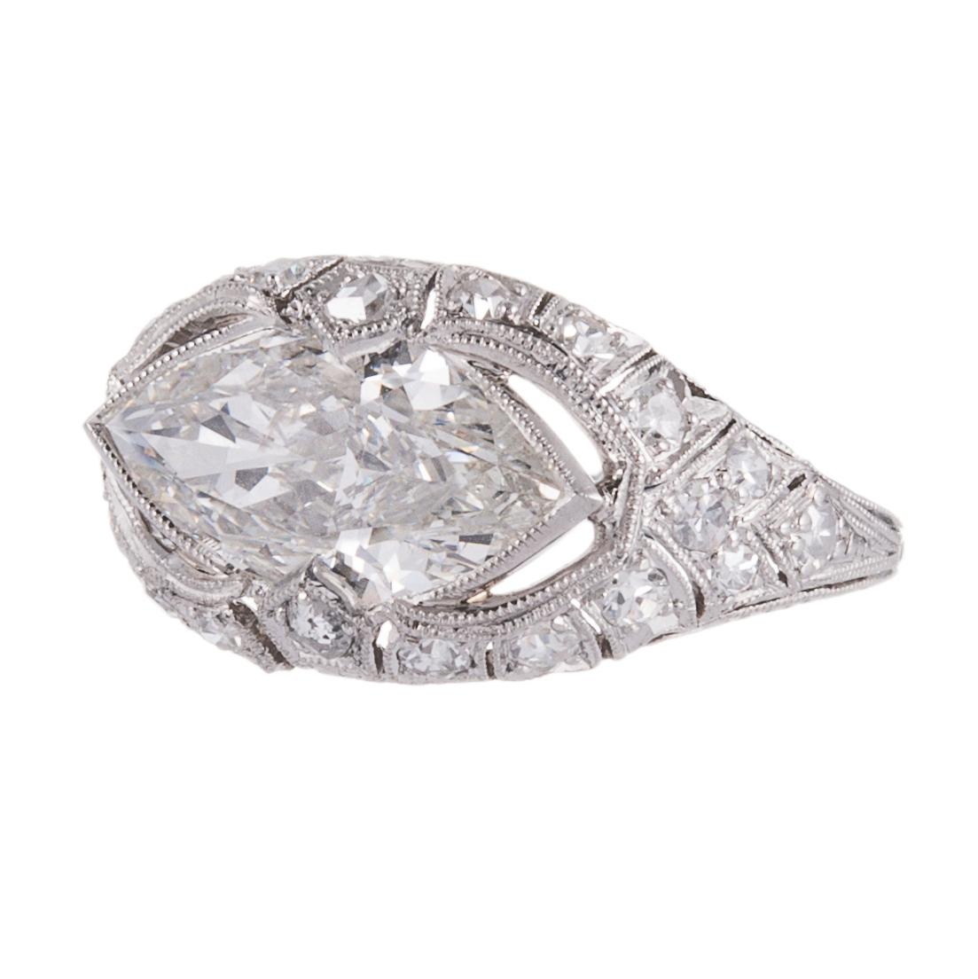 An art deco inspired platinum ring, ideal for the non-traditional bride or she who seeks a truly unique, yet timeless design. The ring oozes detail at every opportunity, with filigree, hand engraving and millegrain. The center diamond is described