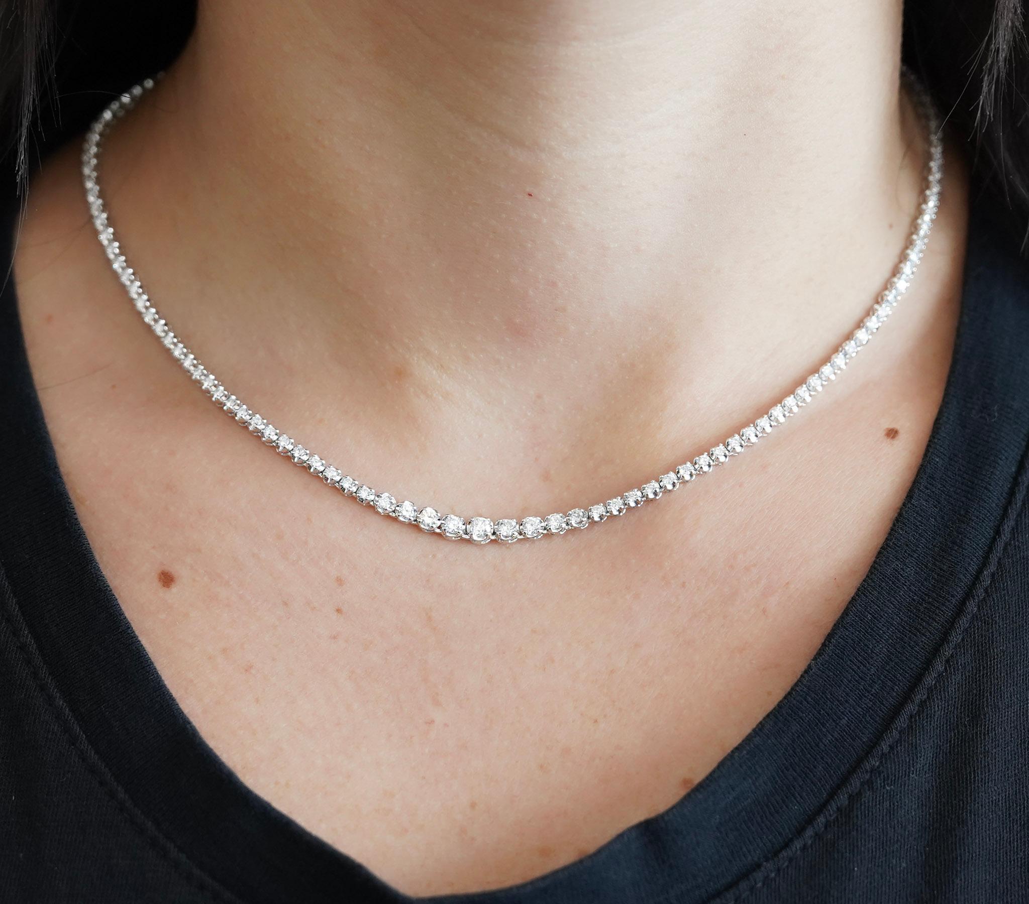 This platinum 900 tennis choker necklace is adorned with a total of 3.09 carats of natural round cut diamonds, arranged in a graduated design. The necklace weighs 17.57 grams and sits at 16.5 inches length. The 4 prong setting has a wide frame
