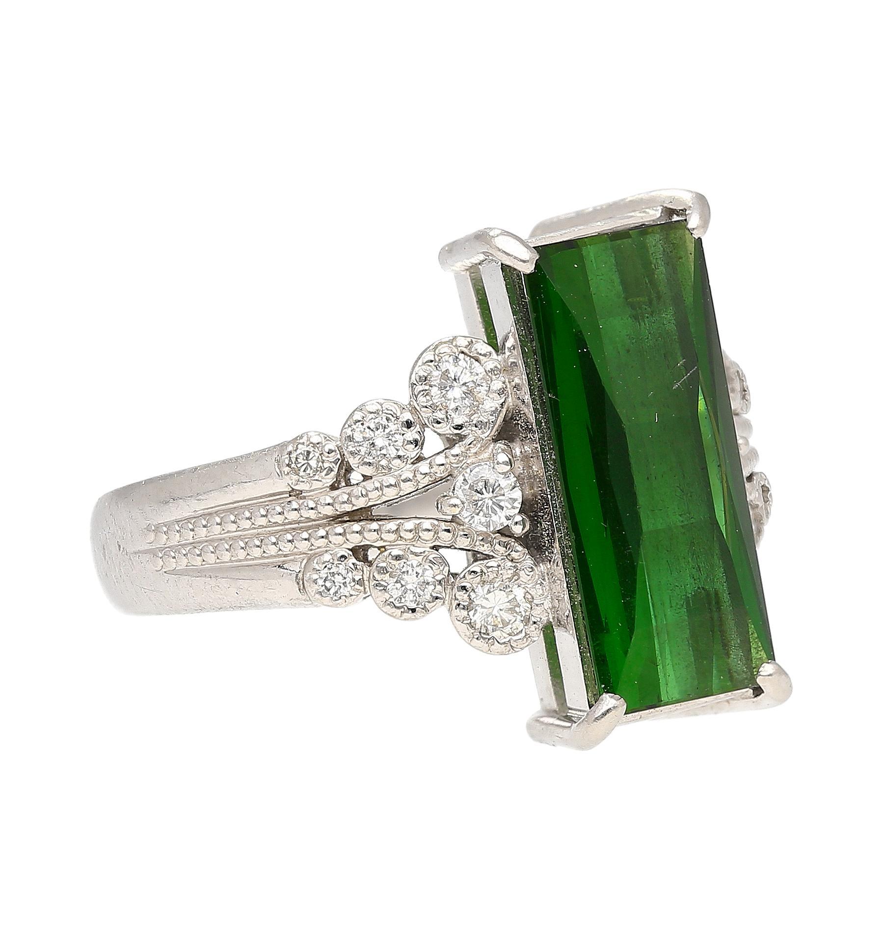 This stunning ring features a vivid green checkerboard-cut 3.19 CT tourmaline stone set on a platinum 900 band. The center stone is complimented by 0.27 Ct round-cut diamonds on either side of the shank. Size 6 and adjustable. The vintage feel of