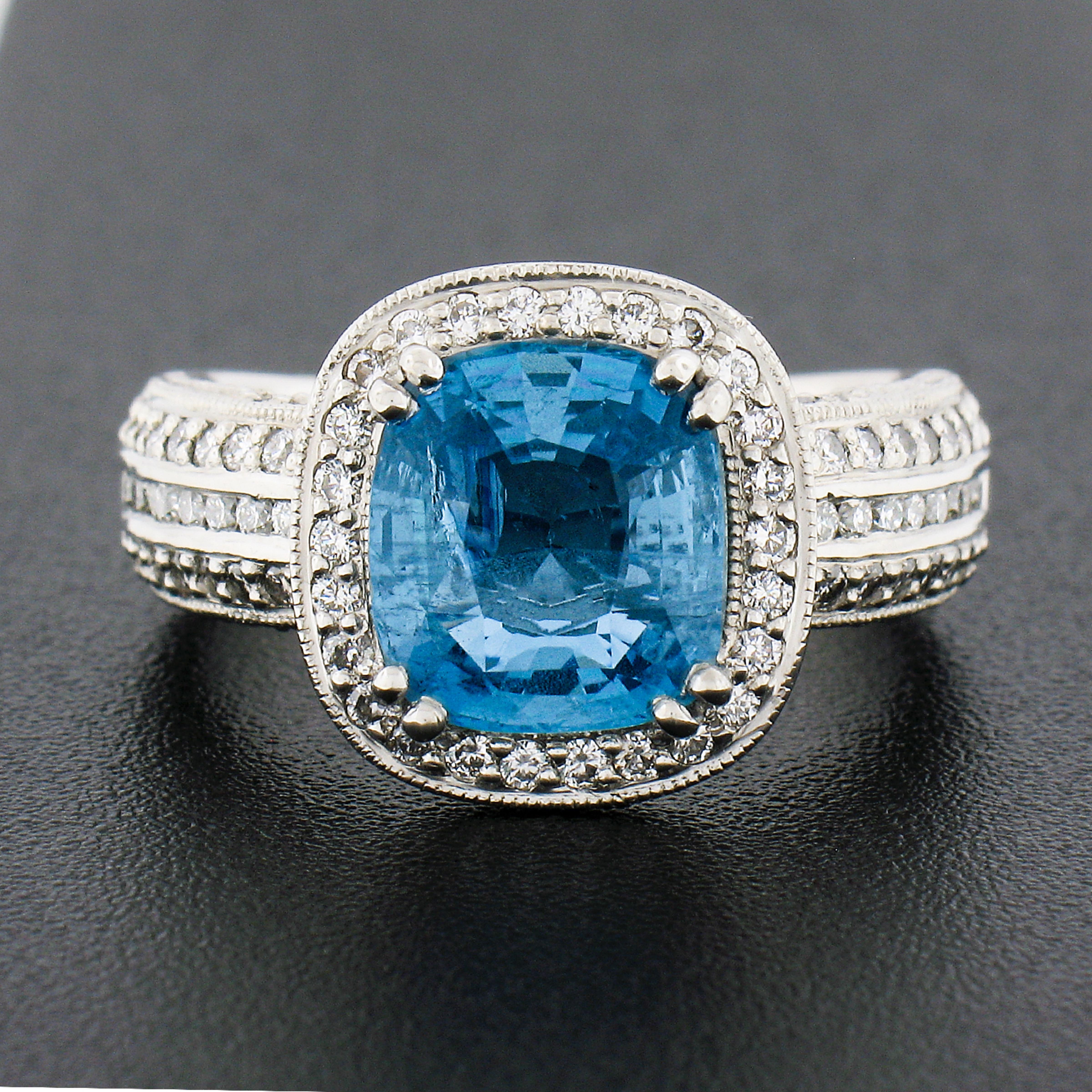 This magnificent and beautifully detailed ring is very well crafted in solid platinum and features a gorgeous aquamarine solitaire with fine quality diamond accents throughout. The elongated cushion cut aquamarine stone is 2.58 carats in weight and