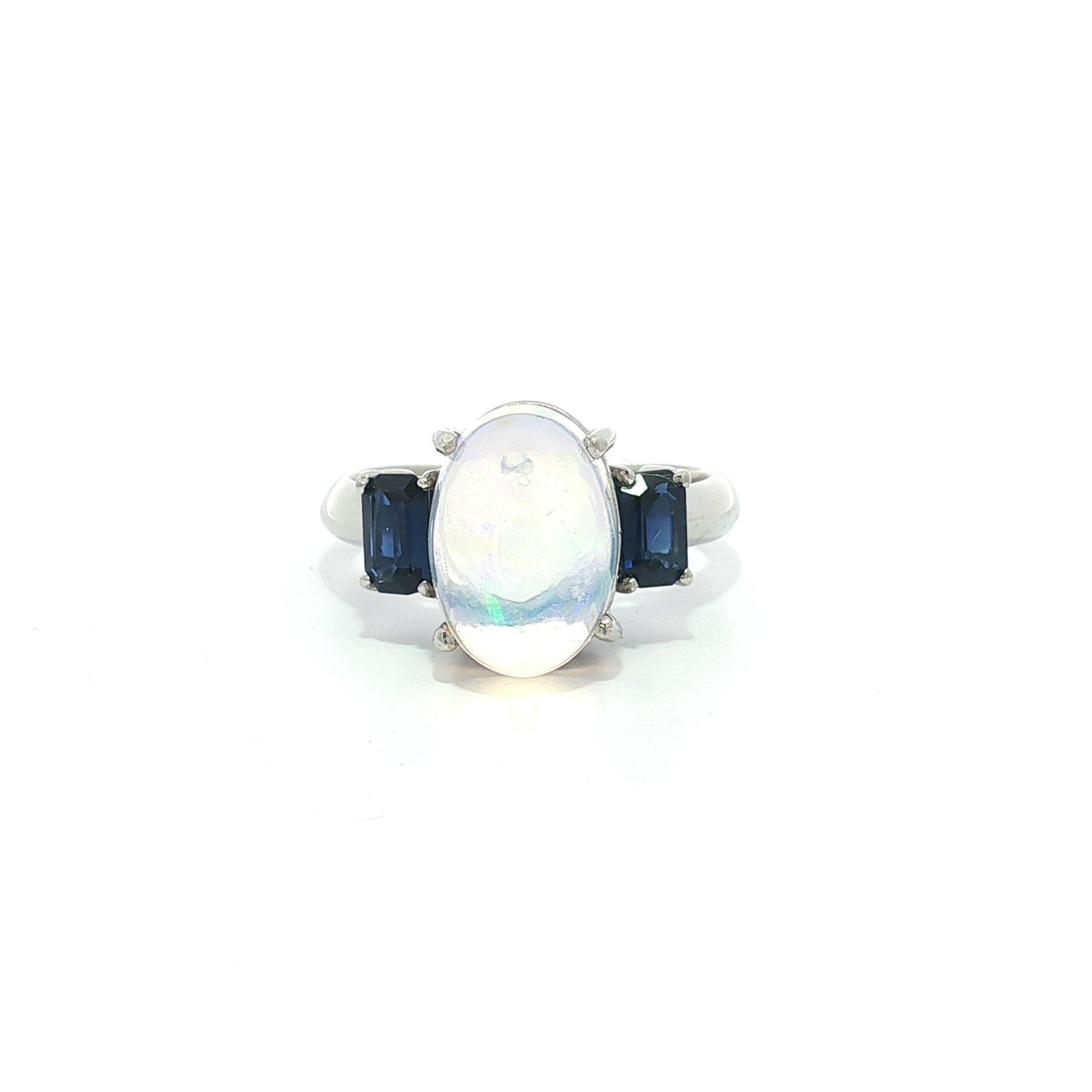 --Pierre(s) :...
(1) Opale Naturelle Véritable - Cabochon Ovale - Serti - Base de couleur blanche avec un incroyable jeu de couleurs bleu et vert - 3.18ct (exact)
(2) Saphirs naturels authentiques - taille émeraude - sertis - couleur bleu riche et