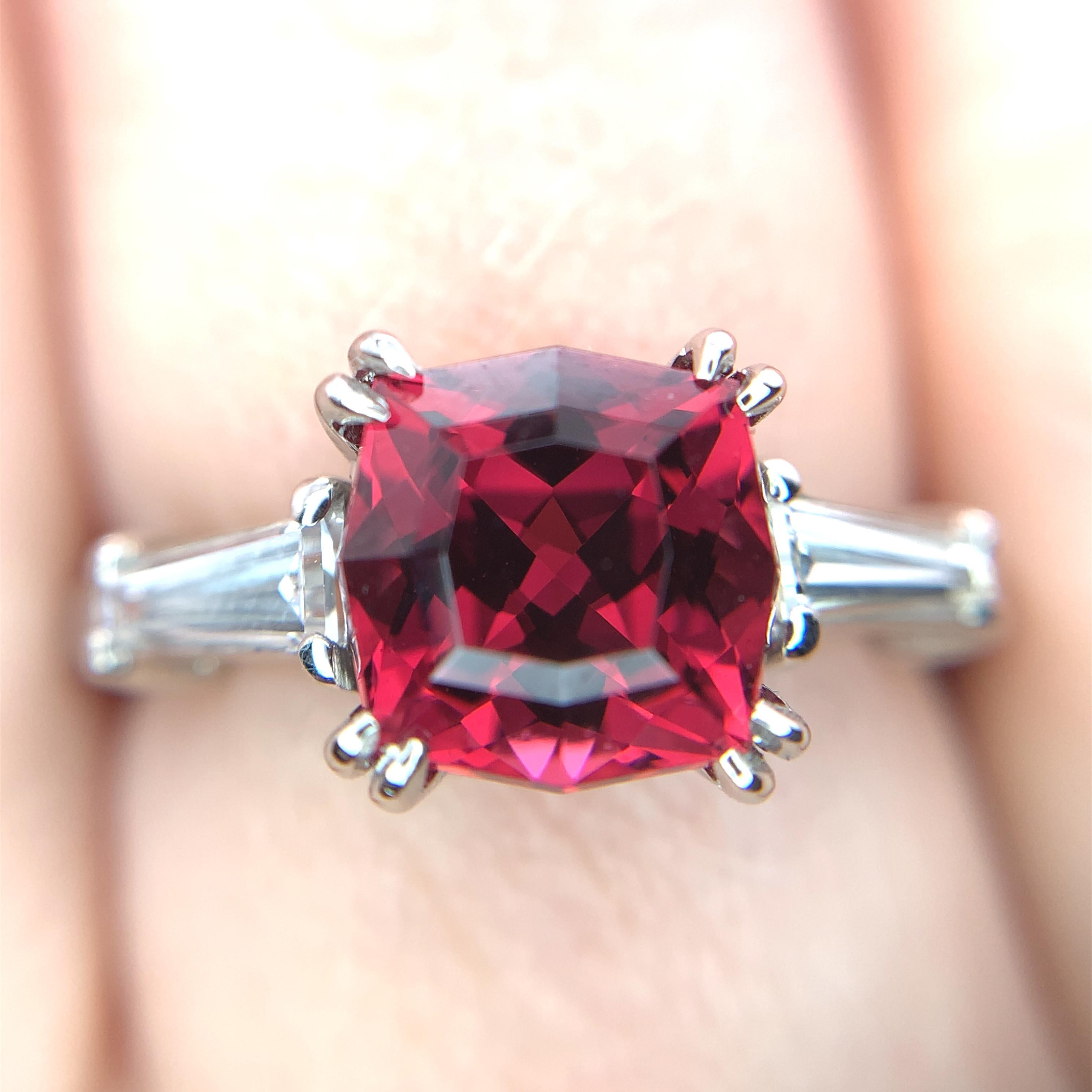 Platinum garnet and diamond ring featuring a 3 carat cushion cut red garnet with tapered diamond baguettes. The garnet has red wine or Bing cherry type burgundy red color. The cushion cut garnet measures about 7.5mm square and weighs 3.01 carats.