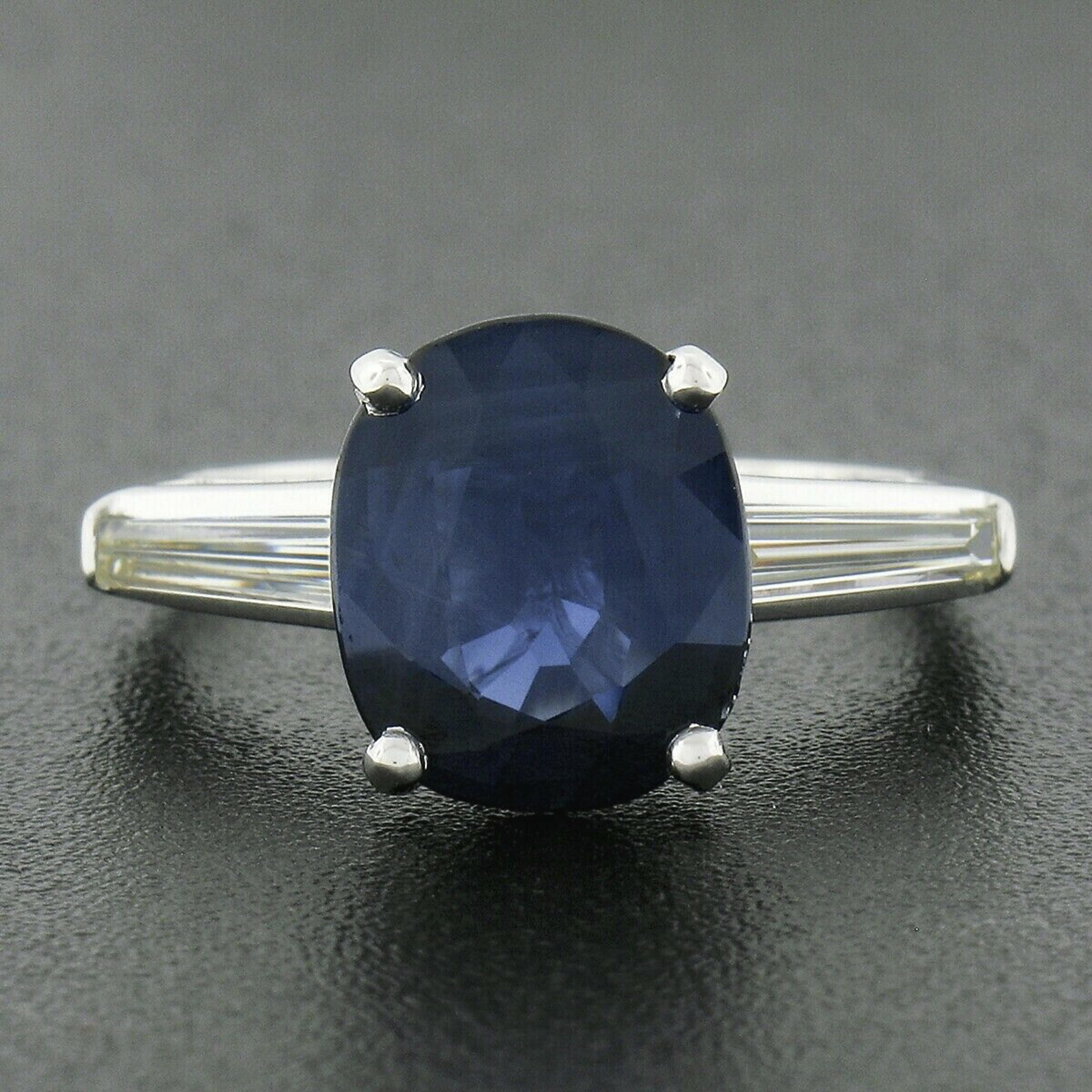 This breathtaking sapphire and diamond classic three stone engagement ring was hand crafted in solid platinum and features a magnificent, Gubelin certified, old sapphire solitaire that's perfectly prong set at the center and flanked on either side
