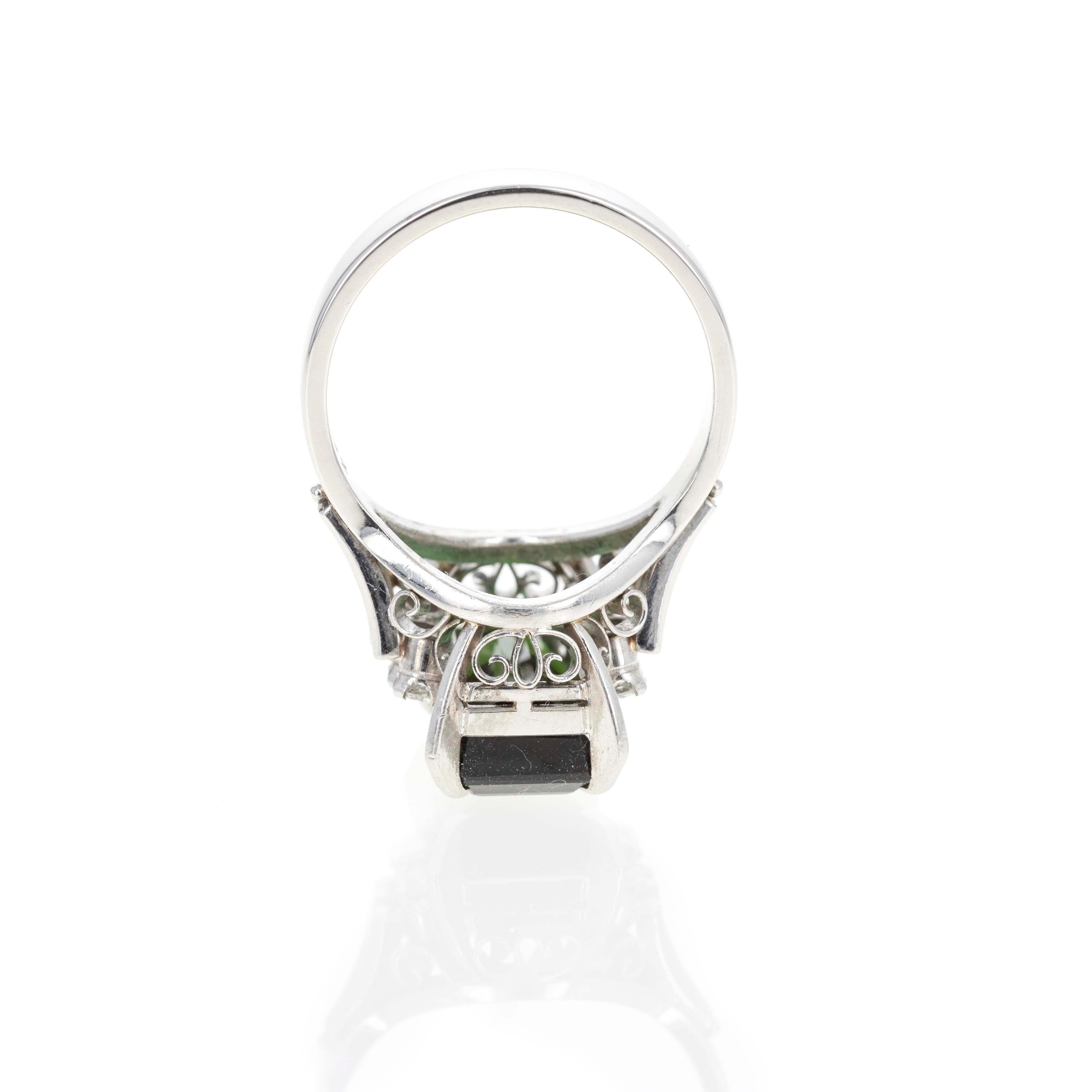 Era: Retro Estate
Composition: Platinum
Primary Stone: Emerald Cut Green Tourmaline
Carat Weight: 4.45 Carats
Accent Stone: Six Round Brilliant Diamonds
Carat Weight: 0.22 Carats in Total
Color/Clarity: G-H / SI1-VS2
Ring Size: 6.5
Ring Weight: 8.2