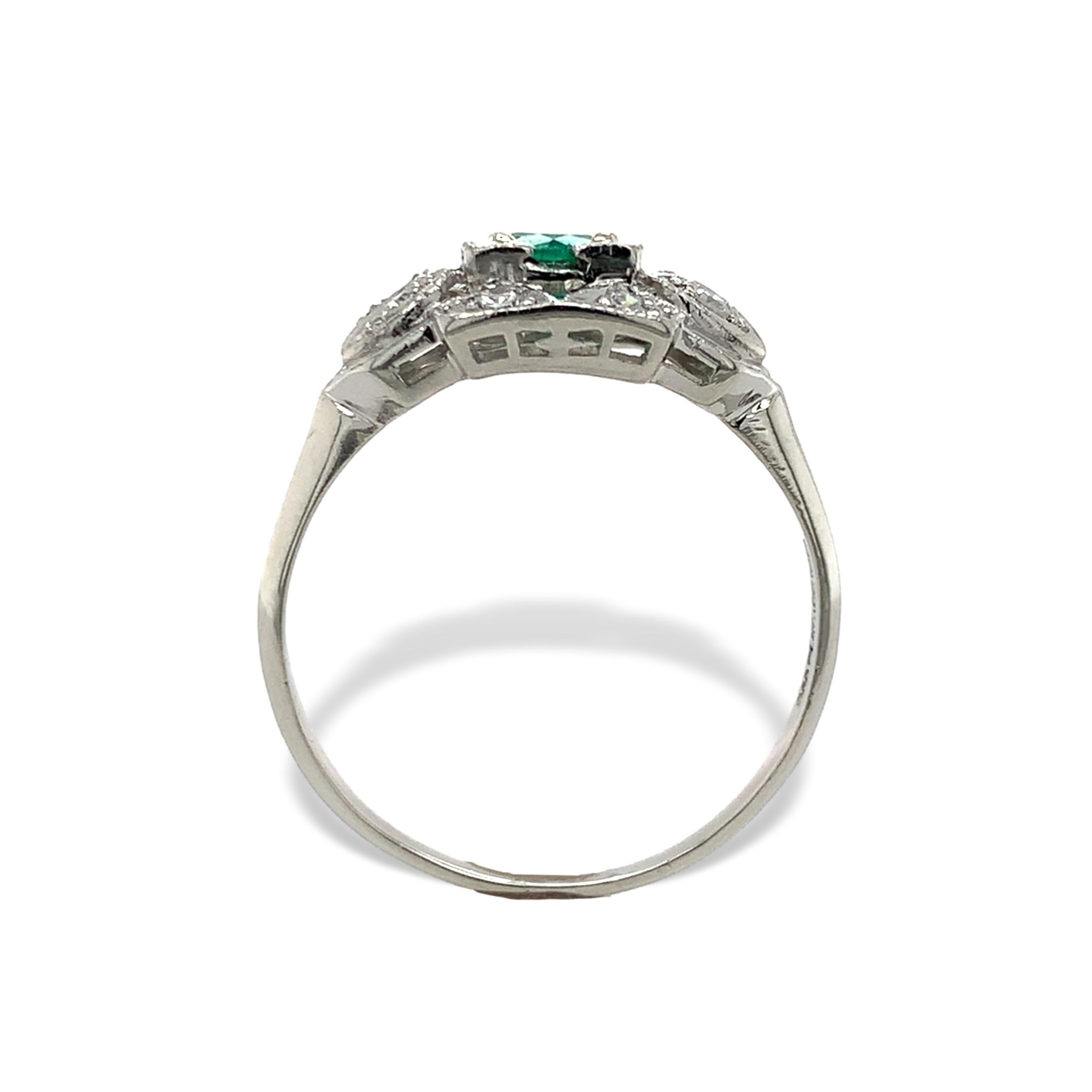 Platinum ring featuring a round emerald weighing .44cts. The genuine earth mined emerald has medium green color and measures about 5mm. There are 8 round single cut diamonds weighing about .15cts total. The natural earth mined diamonds have SI