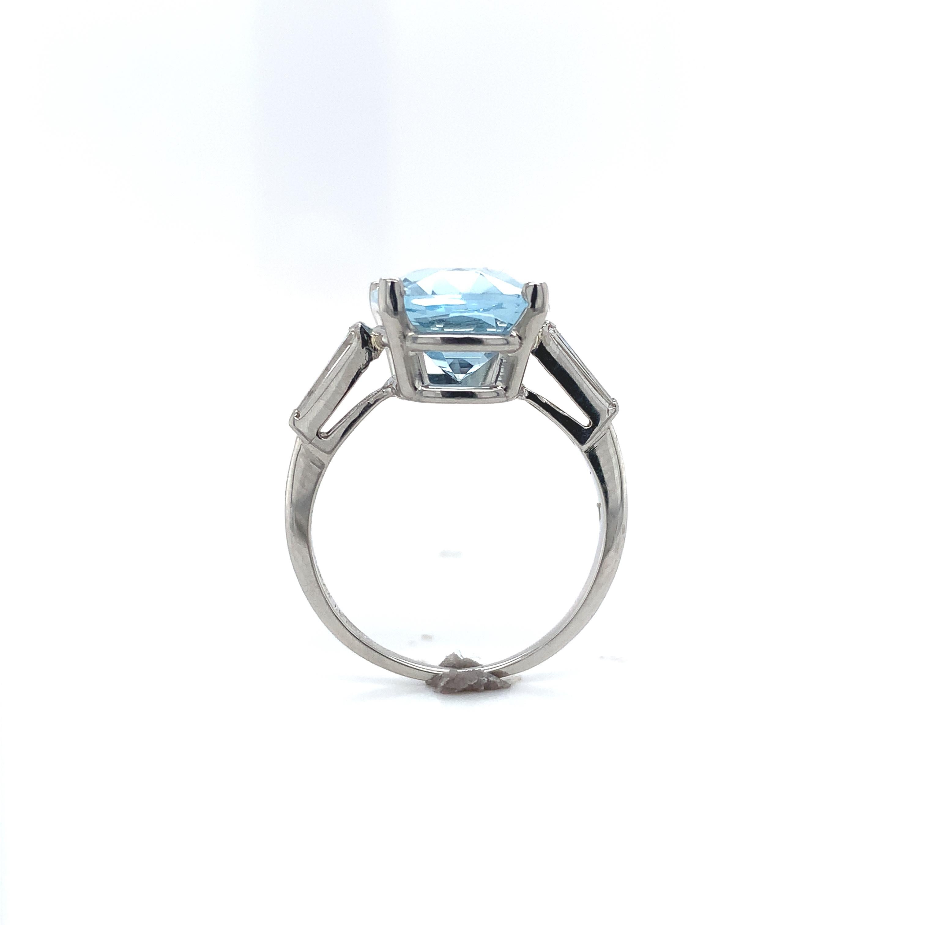 Platinum 4.71 carat aquamarine and diamond ring. The light blue aquamarine is a beautiful specialty antique cushion cut measuring about 12.3mm x 9.8mm. There are 2 long diamond baguette accents measuring about 5.5mm x 2mm. The ring fits a size 6.75