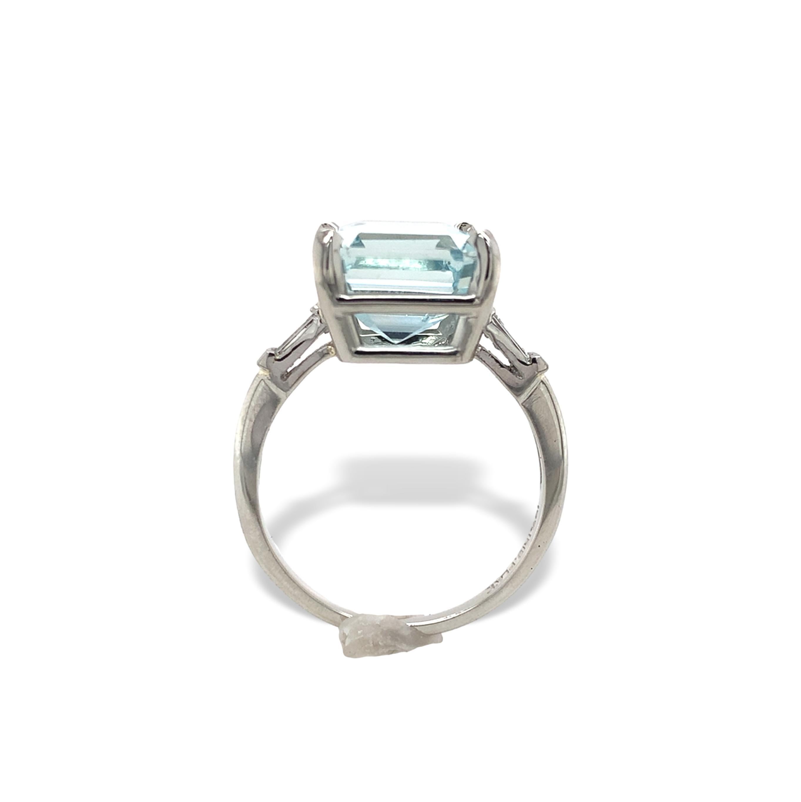 Platinum ring featuring a 4.80 carat asscher cut aquamarine and diamond ring. The aqua is a pale blue color measuring about 10.2mm x 9.7mm. There are 2 baguette diamonds weighing .18cts total. The ring fits a 6.5 and weighs 2.54dwt.
It dates from