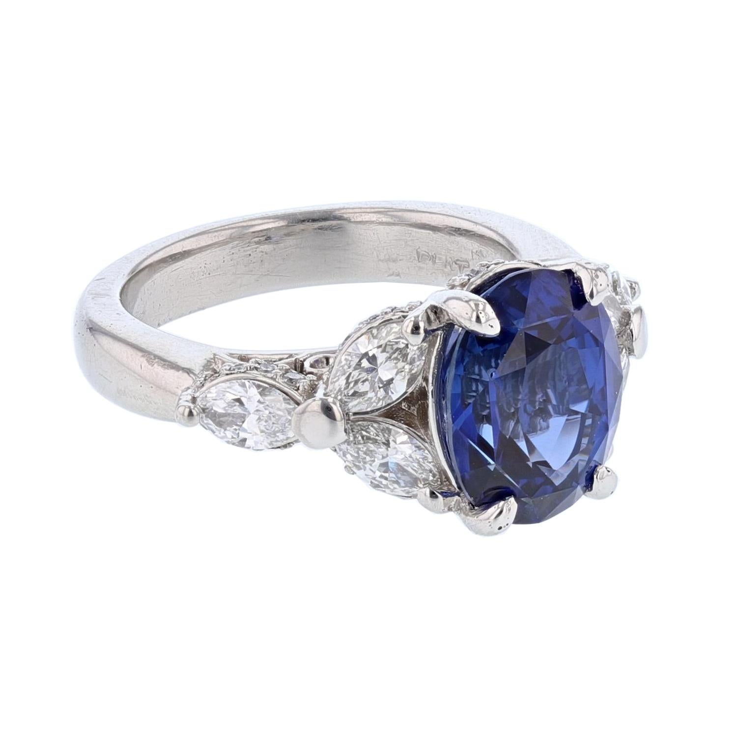This ring is made in Platinum and features one GRS certified Oval Cut, Natural Blue Sapphire weighing 5.01ct, prong set, originating from Sri Lanka. The GRS report number is GRS2014-077118. The ring also has a features 6 Marquise cut diamonds
