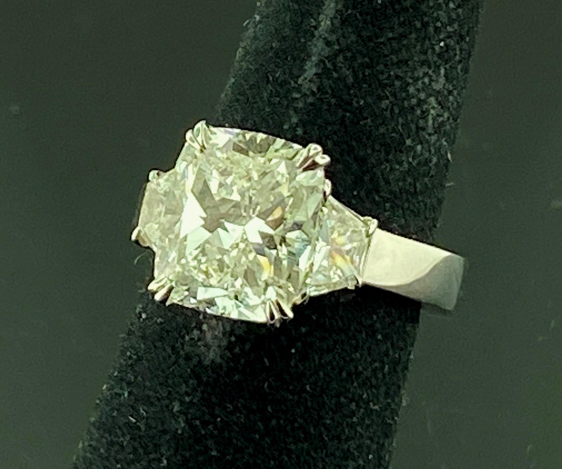 Set in Platinum, weighing 11.72 grams, is a 5.02 carat Cushion Cut Diamond, GIA Certificate # 110112051064, Color Grade of: I, Clarity Grade of: VS-2. On the sides are two Trapezoid Cut diamonds weighing 1.25 carats total weight, Color Grade of: I,