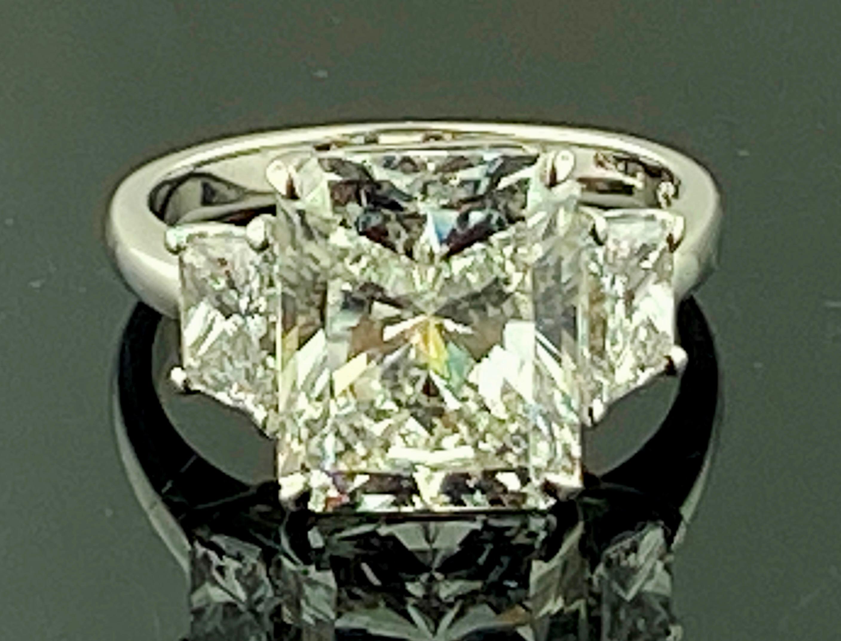 Set in Platinum, weighing 6.93 grams, is a 5.39 carat Radiant Cut Diamond, GIA Report #110112107523, Color: I, Clarity: SI-1.  On the sides are two Trapeziod cut diamonds with a total diamond weight of 1.20 carats, Color: G-H, Clarity: VVS.  Ring