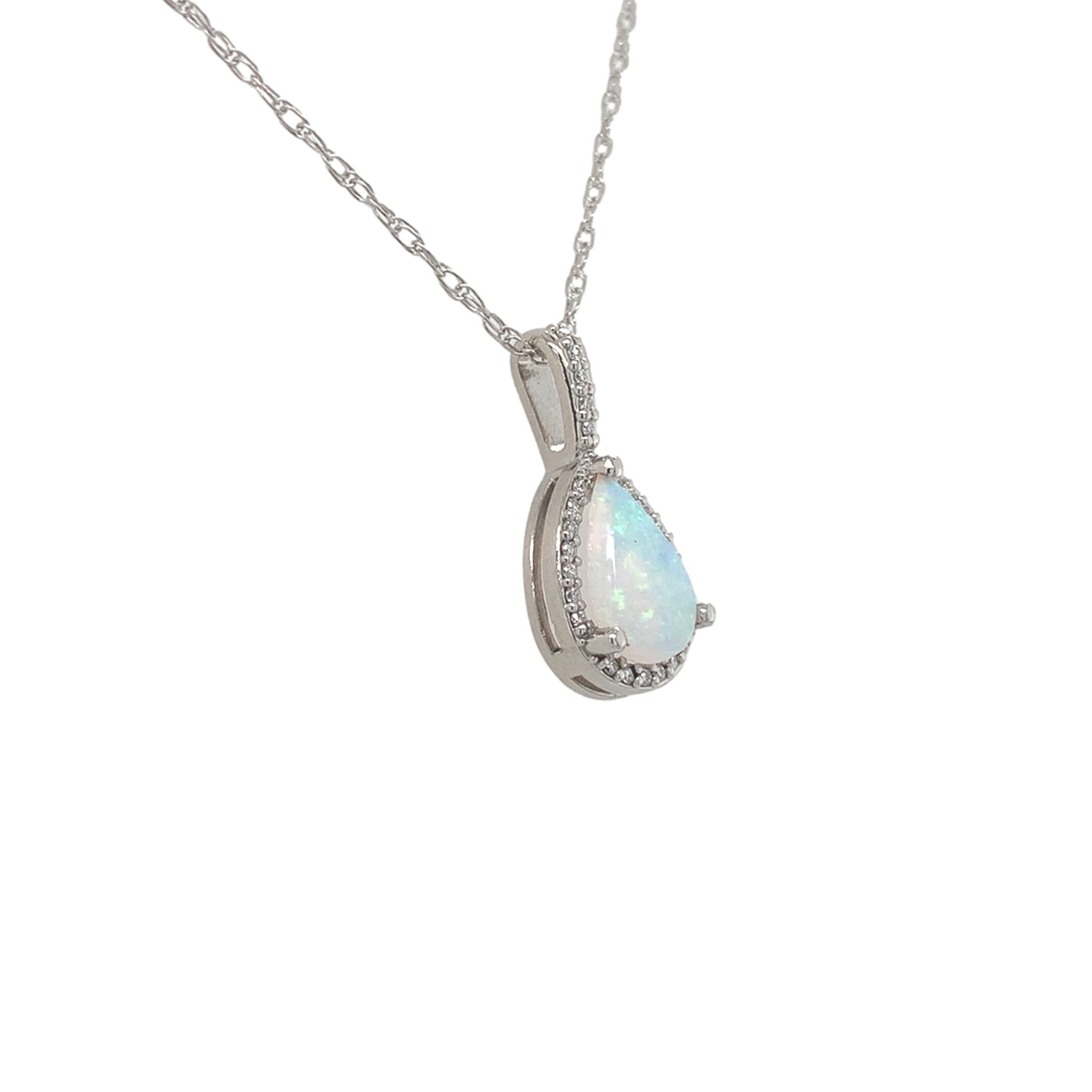 Ciondolo in platino con opale australiano estratto dalla terra e diamante. L'opale con taglio a pera misura circa 8 mm x 6 mm e presenta un vivace gioco di colori con flash principalmente blu-verdi. L'opale pesa .54 carati. Ci sono 25 piccoli