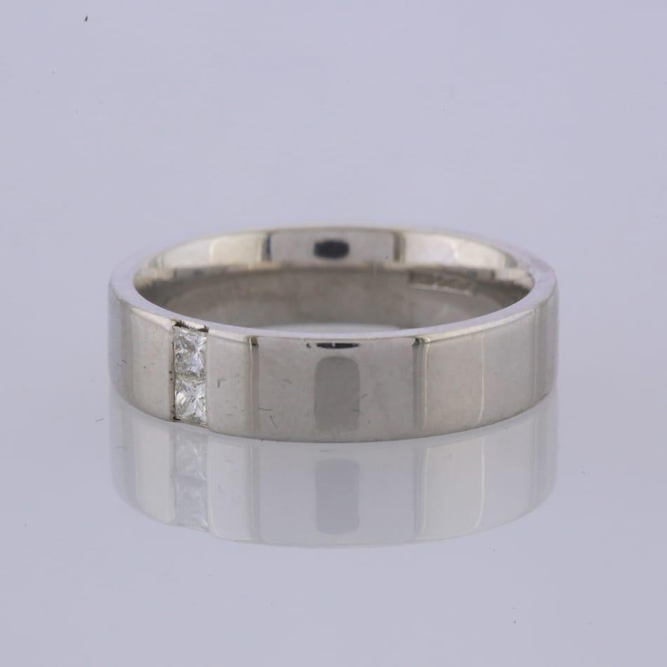 Se trata de una alianza de platino, engastada con 2 diamantes talla princesa.

Estado: Usado (Excelente)
Peso: 3.4 gramos
Talla: O
Ancho de banda: 5 mm
Peso total en quilates del diamante: Aprox. 0,12 quilates
Detalles del diamante: Color: G-H,