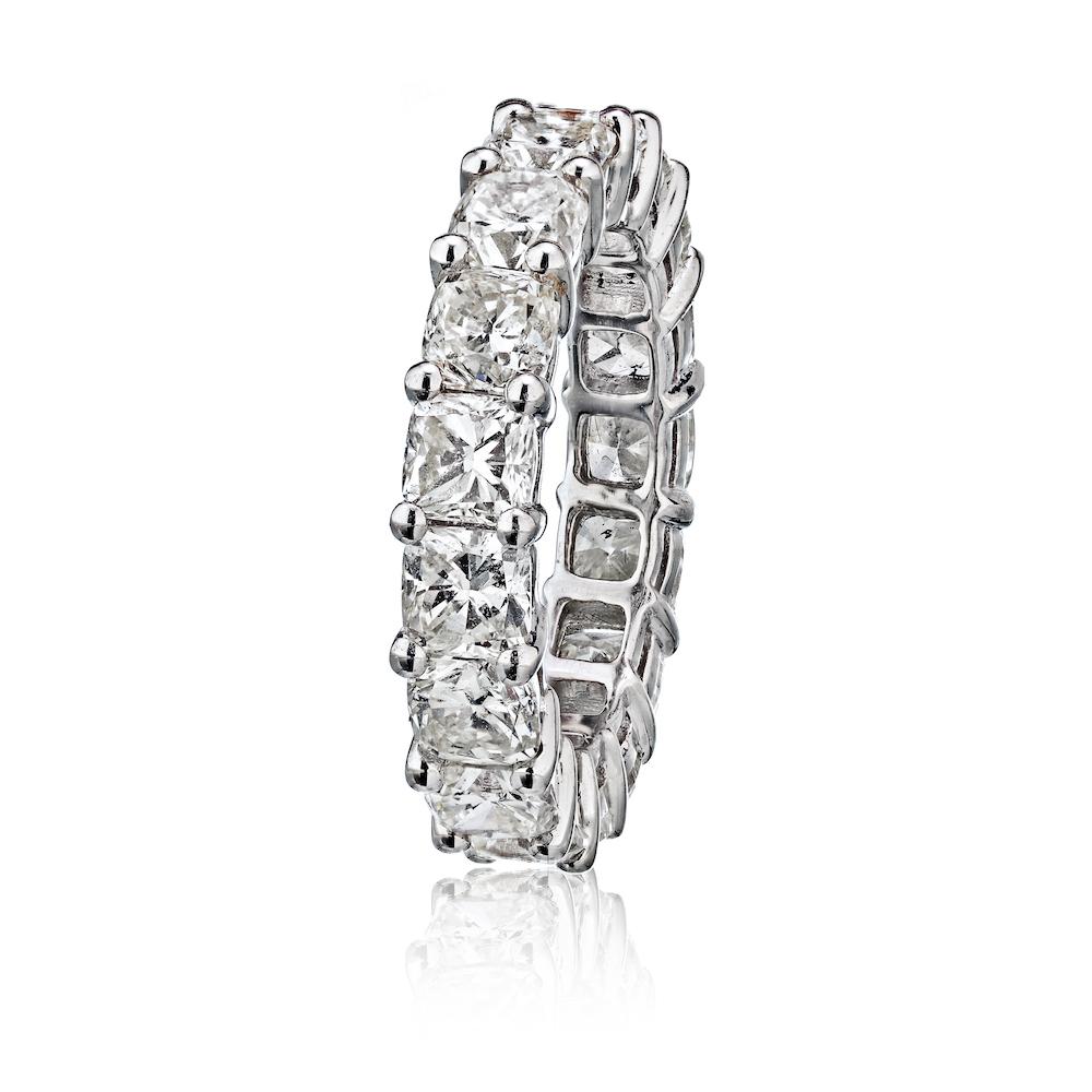 This modern wedding band has (17) handset cushion cut diamonds running the entire length of the band. Each diamond weighs about 0.35ct each totaling in 6.00 carats. This classic style eternity band would work with an engagement ring with any shape