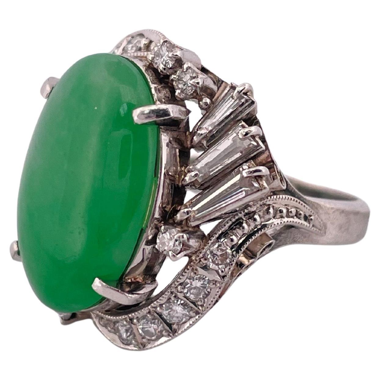 Questo squisito anello in platino mette in mostra un affascinante cabochon di giada naturale da 6,17 carati, che irradia una ricca e vibrante tonalità verde che incarna un'eleganza senza tempo. Intorno alla giada ci sono 0,84 carati di diamanti