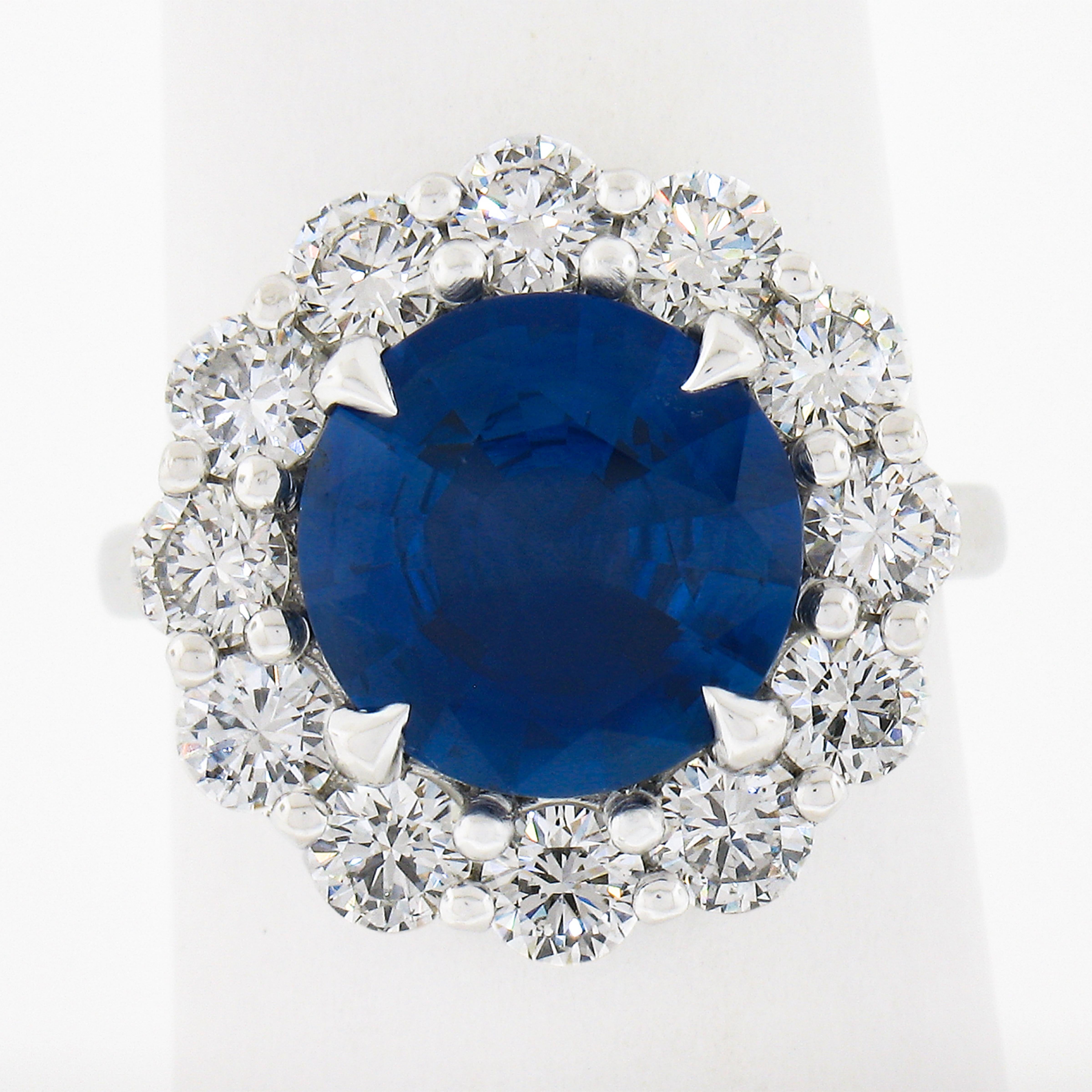 Questo anello di grande effetto è realizzato in platino massiccio e presenta uno splendido zaffiro rotondo taglio brillante, certificato GIA, incastonato al centro di una magnifica aureola di diamanti. Il grande zaffiro pesa 4,55 carati ed è di un